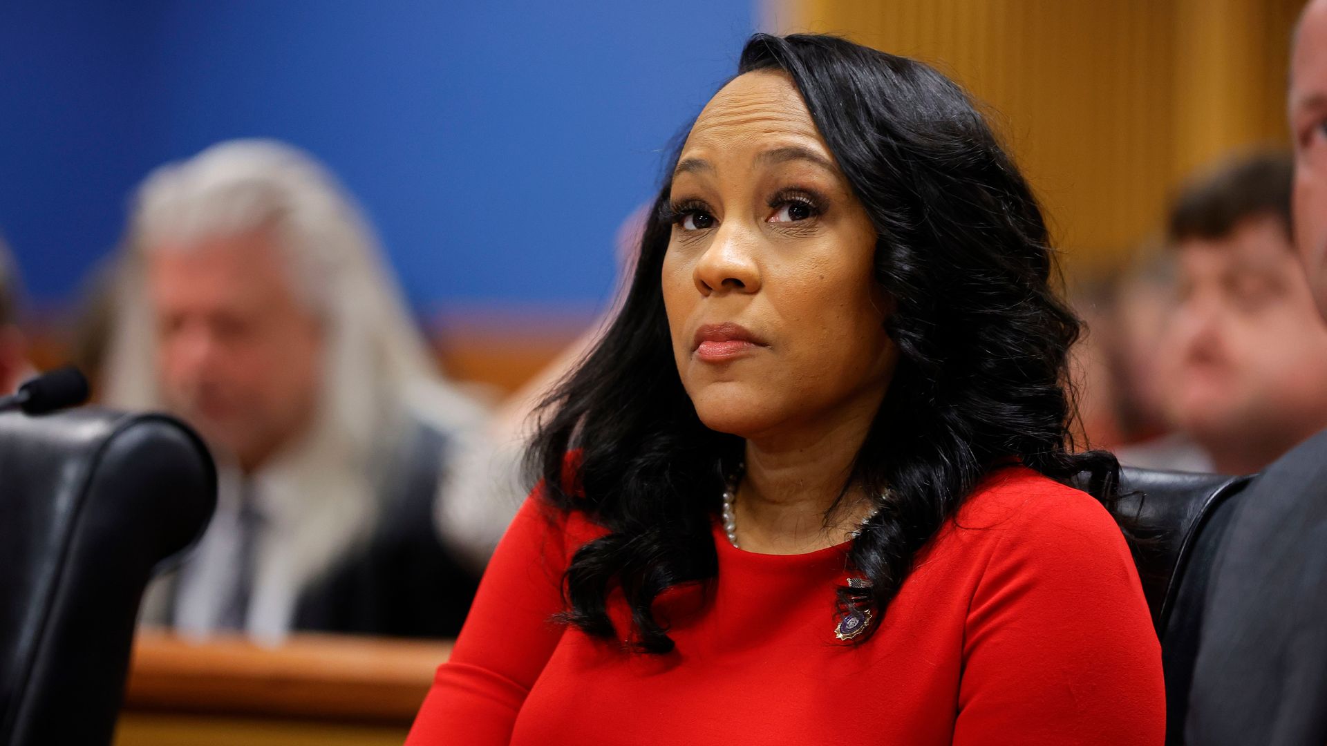 Fani Willis sits in court wearing red 