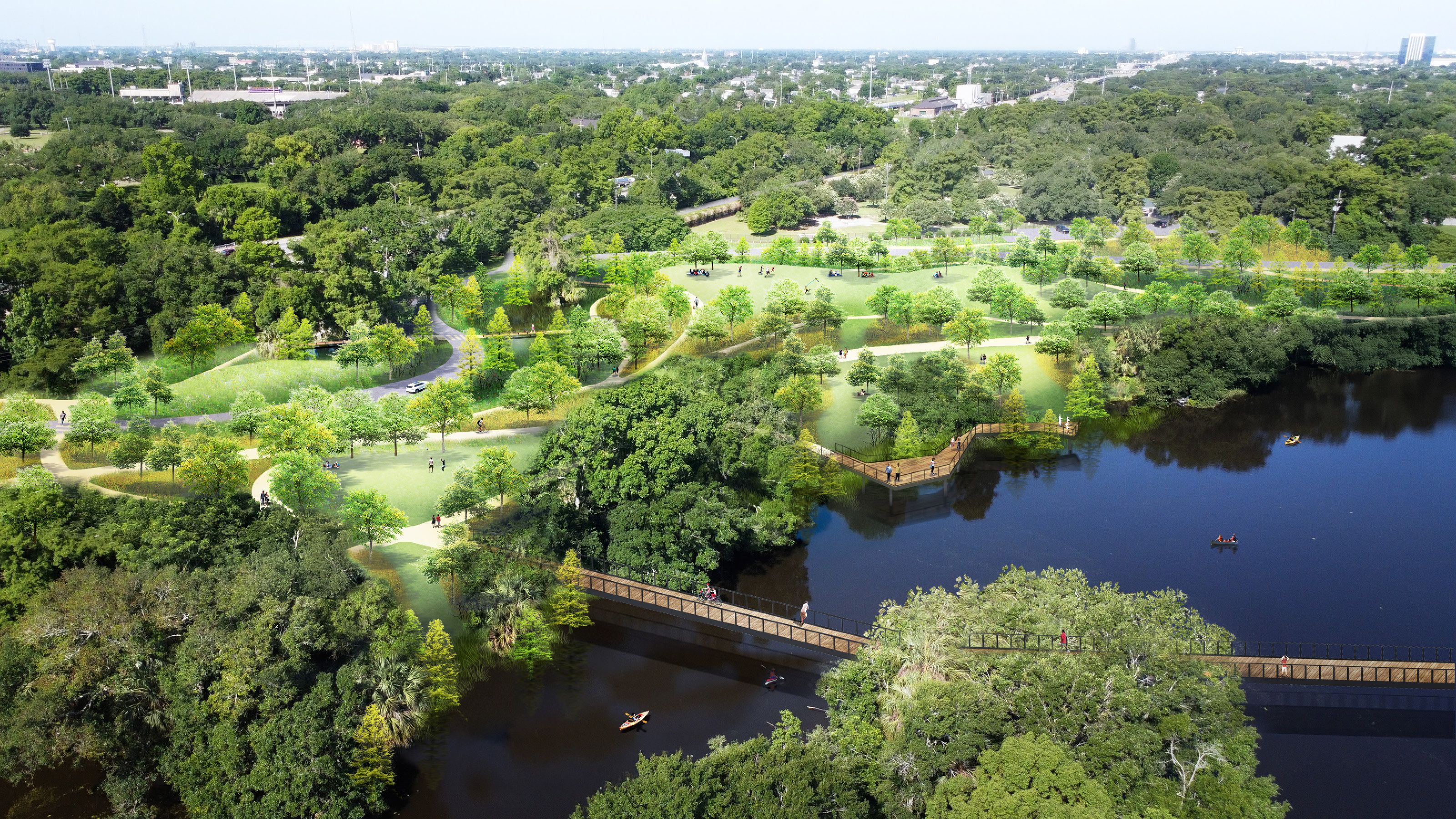 Aerial view of a lush park with winding paths, green lawns and numerous trees. People are visible walking, sitting and enjoying the outdoor space. A river flows through the park, with two bridges crossing it. Small boats and kayaks can be seen on the water. The background features a cityscape.