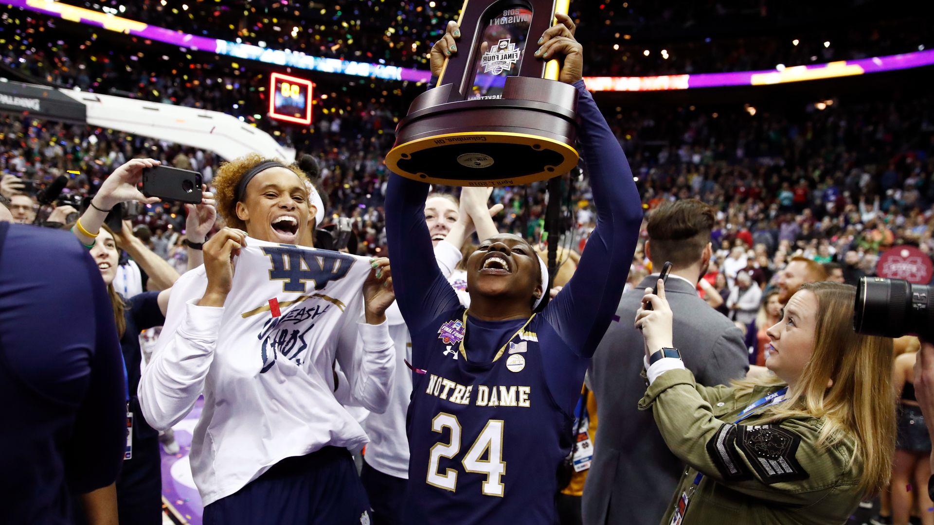 Arike Ogunbowale, No. 24, of the Notre Dame Fighting Irish hoists the NCAA championship trophy as confetti falls