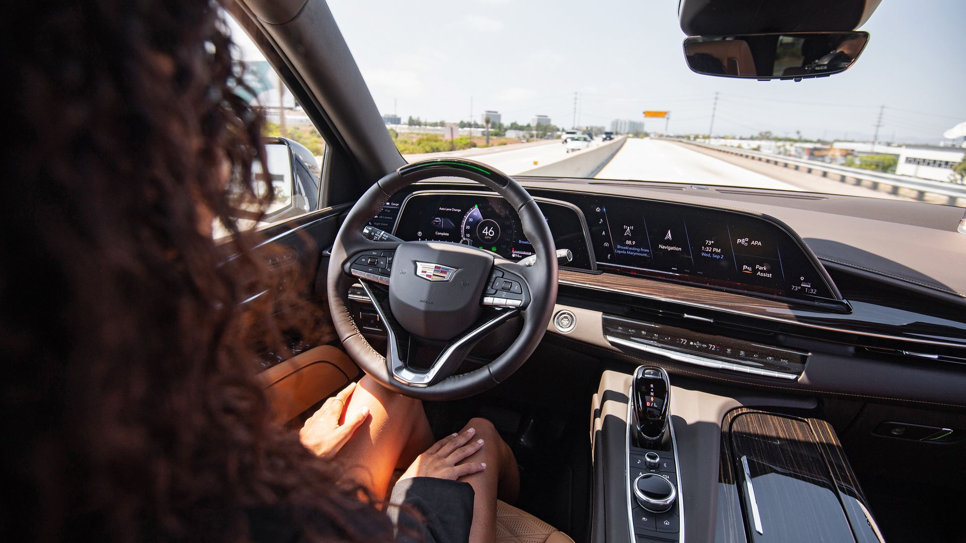 Image of a woman driving a Cadillac Escalade with hands-free Super Cruise technology