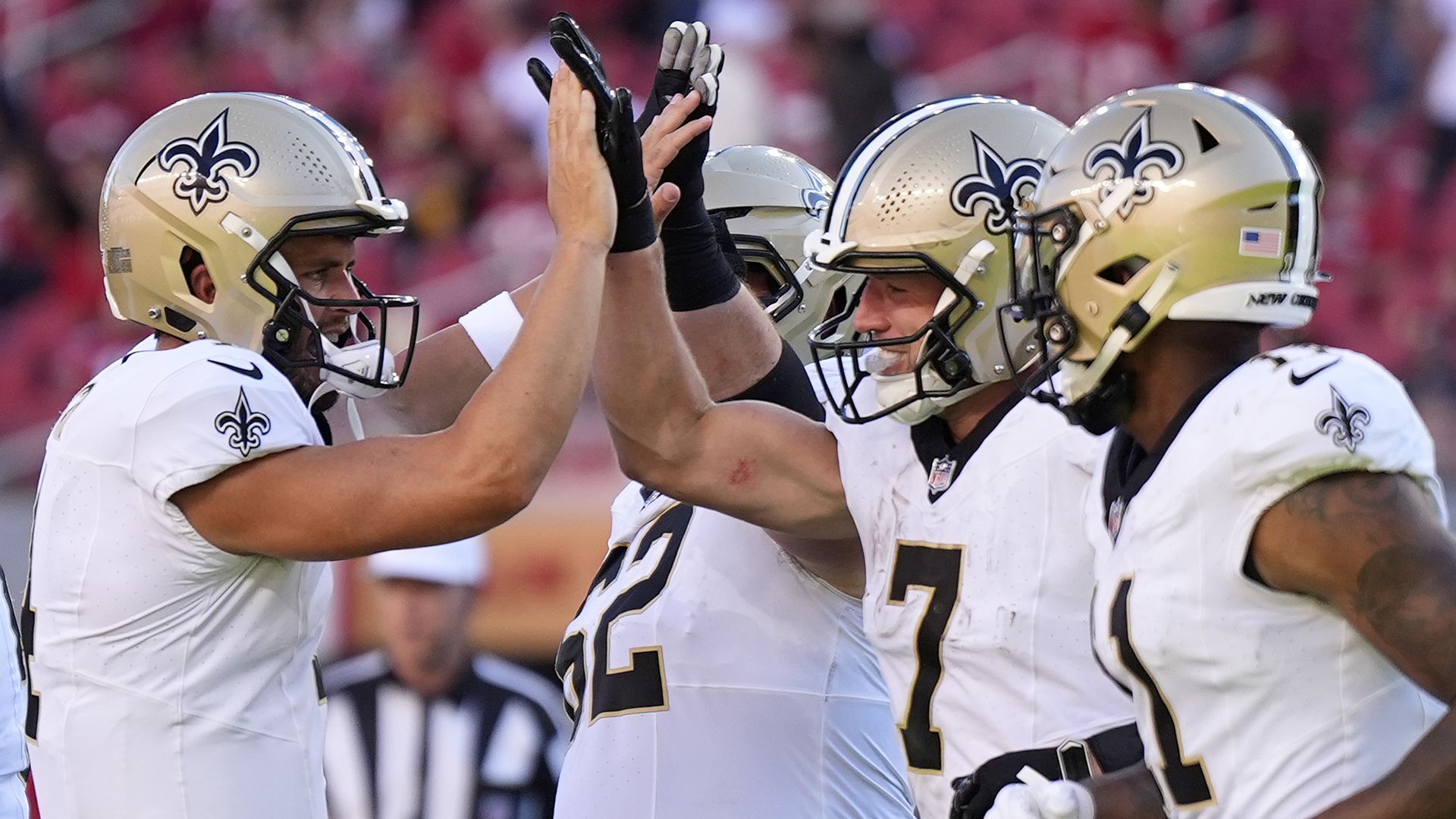 Taysom Hill and Derek Carr high-five each other.