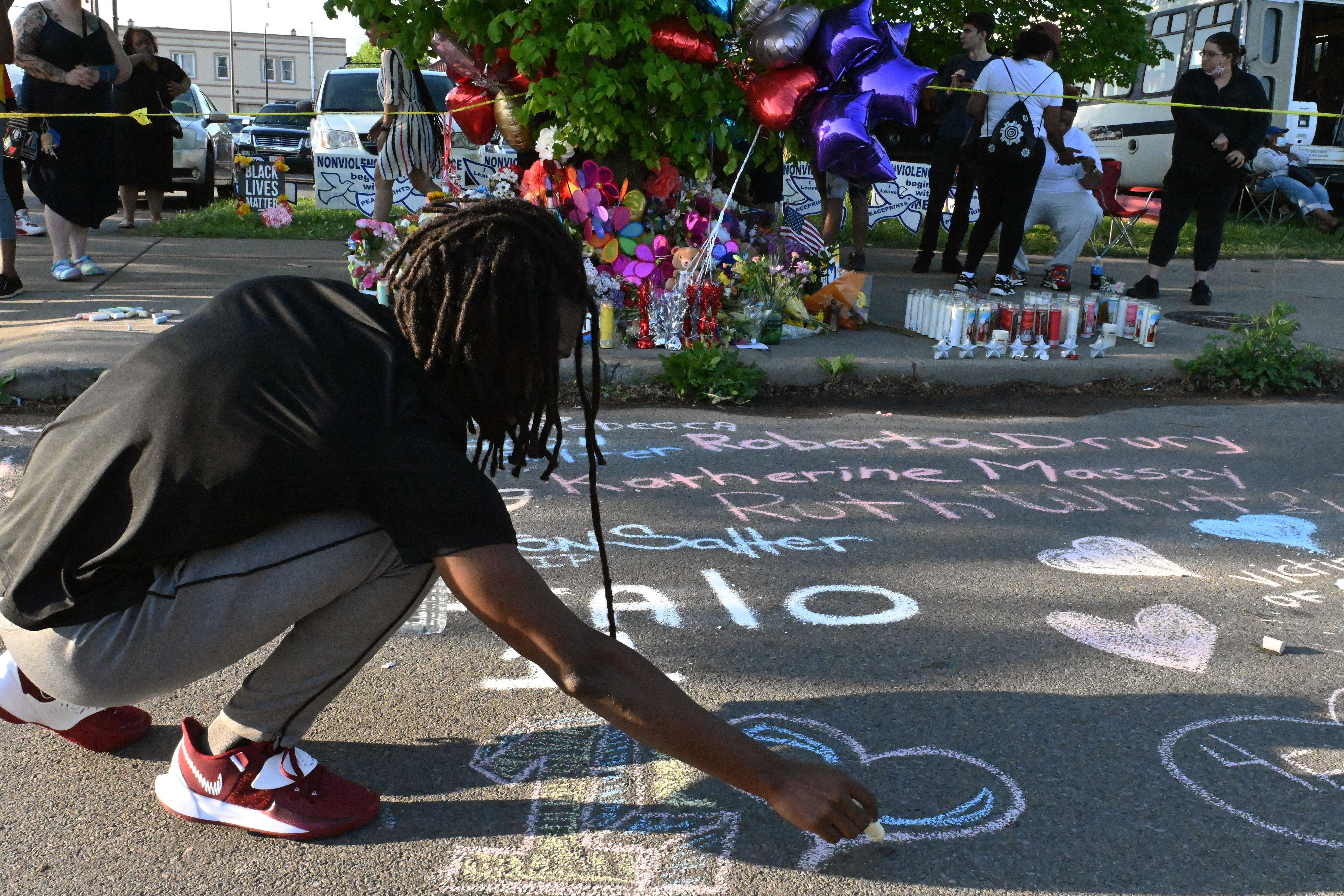 People leave messages at a makeshift memorial near a Tops Grocery store in Buffalo, New York, on May 15,