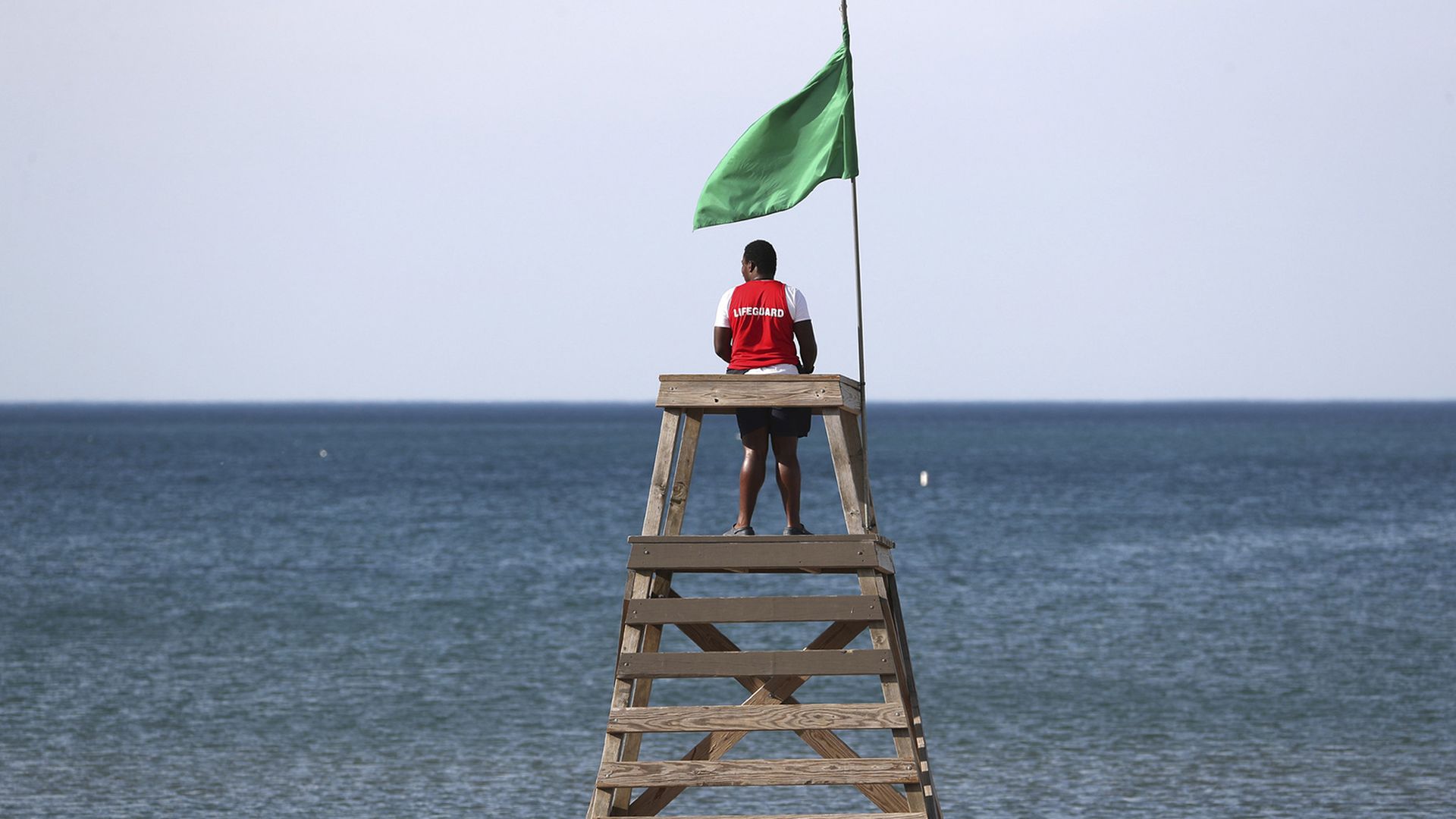 Photo of a lifeguard looking out to a lake