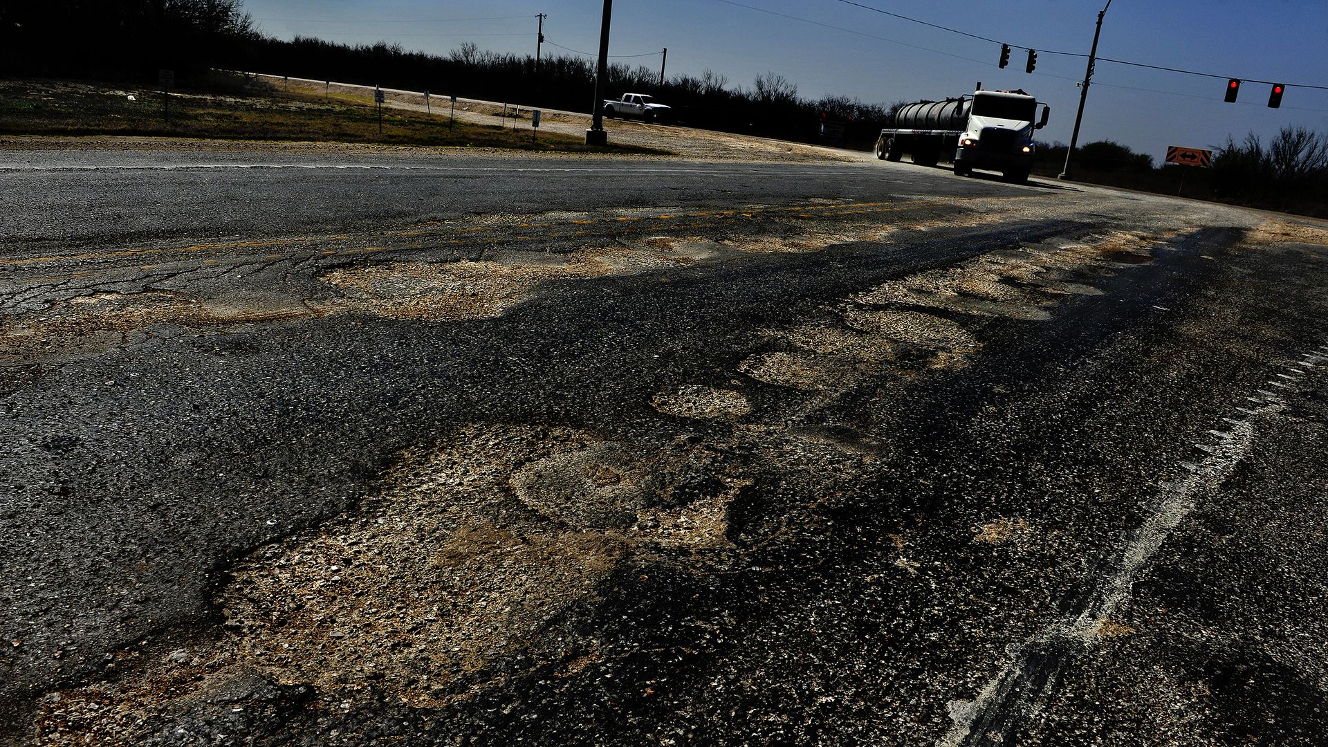 Sections of Highway 72 near Fowlerton, Texas, show the wear and tear from the huge amount of oil industry truck traffic.