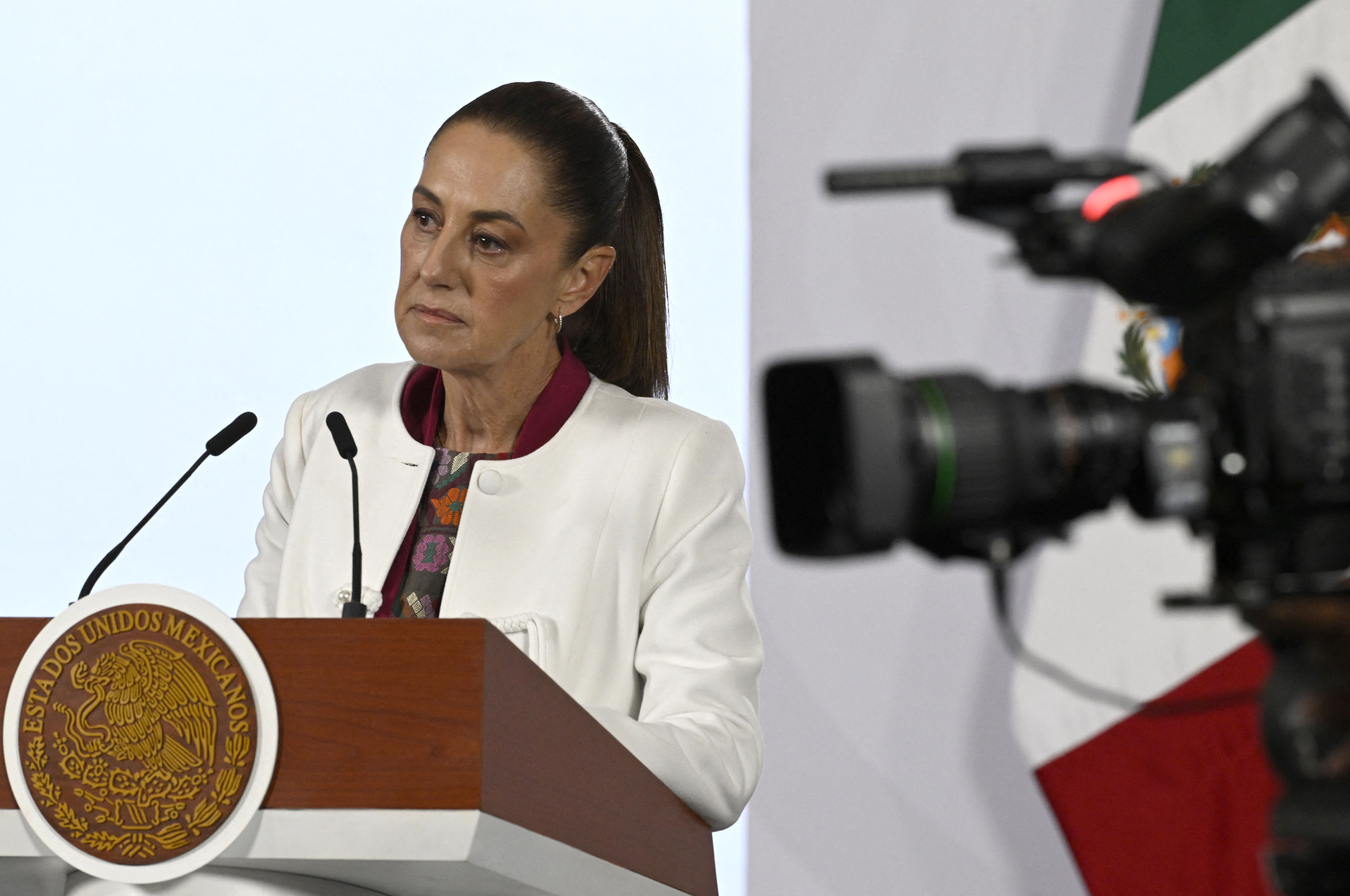 Mexico’s President Claudia Sheinbaum at a podium answering questions during a press briefing at the National Palace in Mexico City.