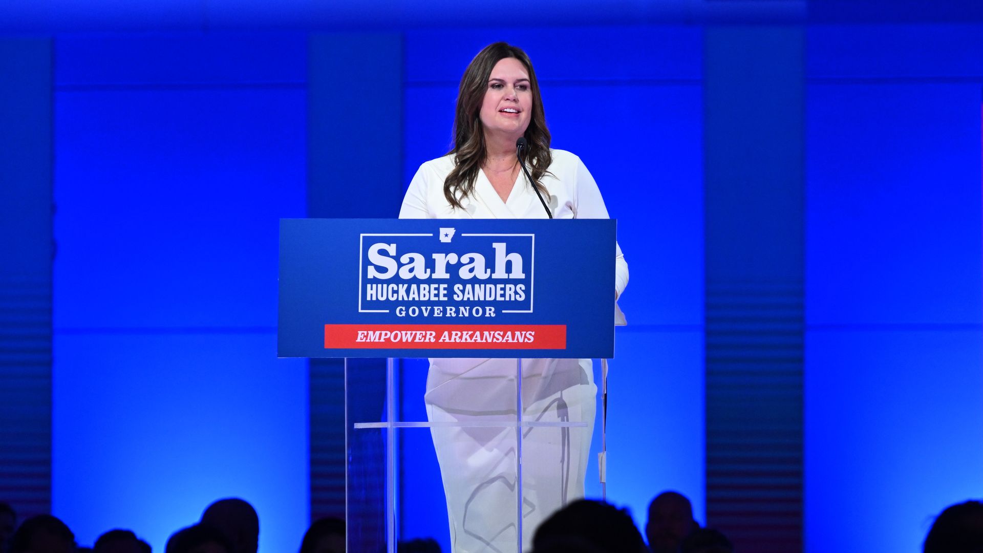 A photo of Sarah Huckabee Sanders at a podium.
