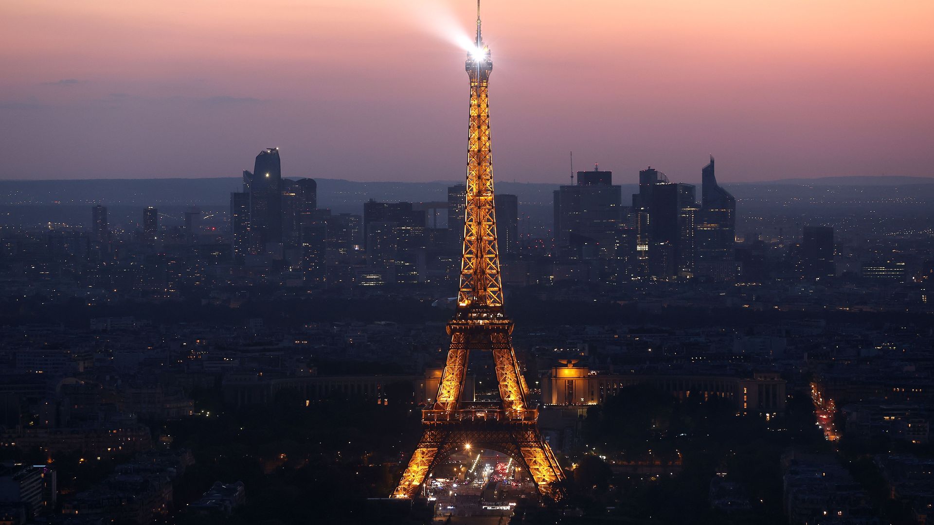 The Eiffel Tower illuminated at dusk. 