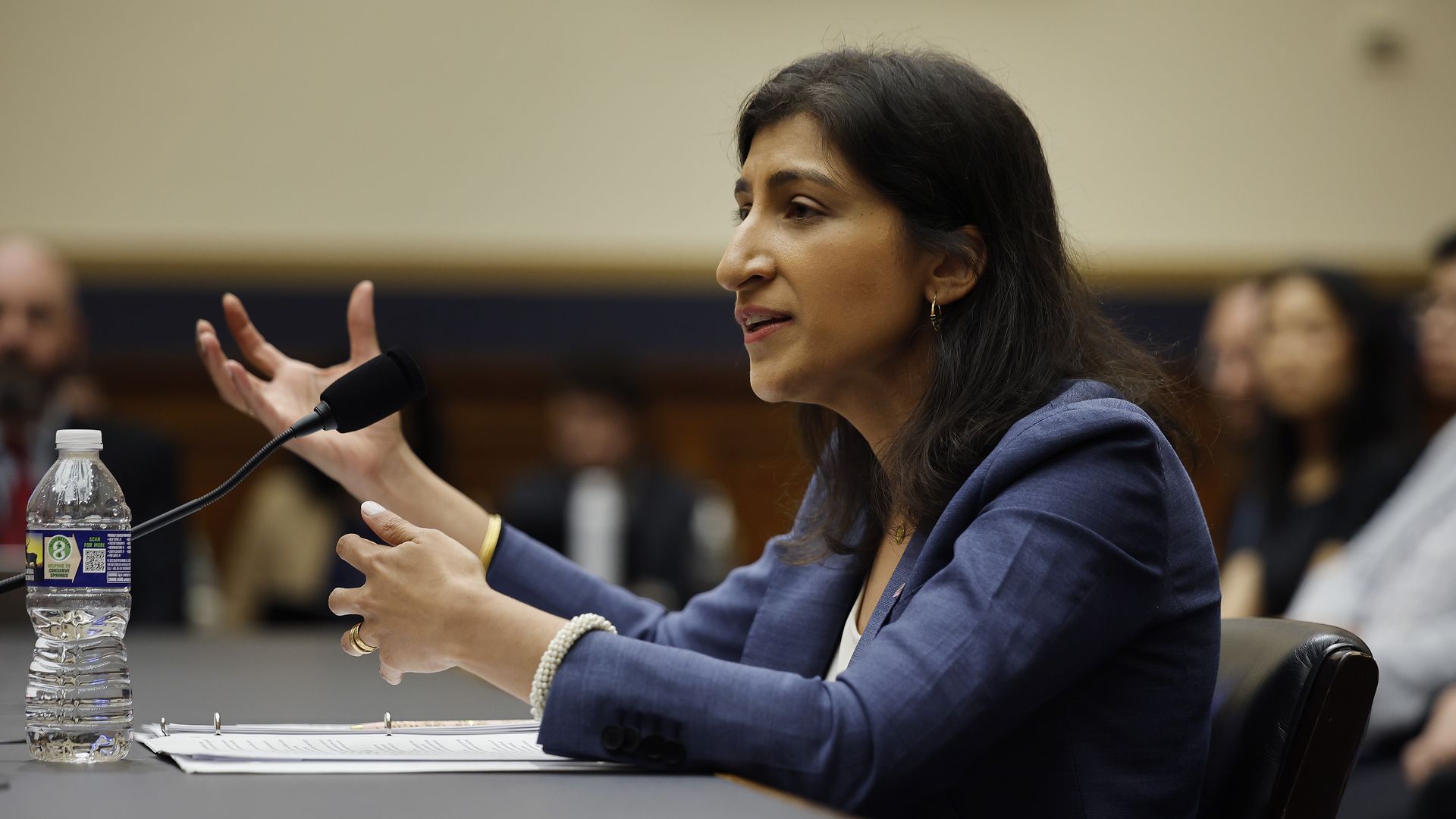 FTC chair Lina Kahn speaking at a desk.