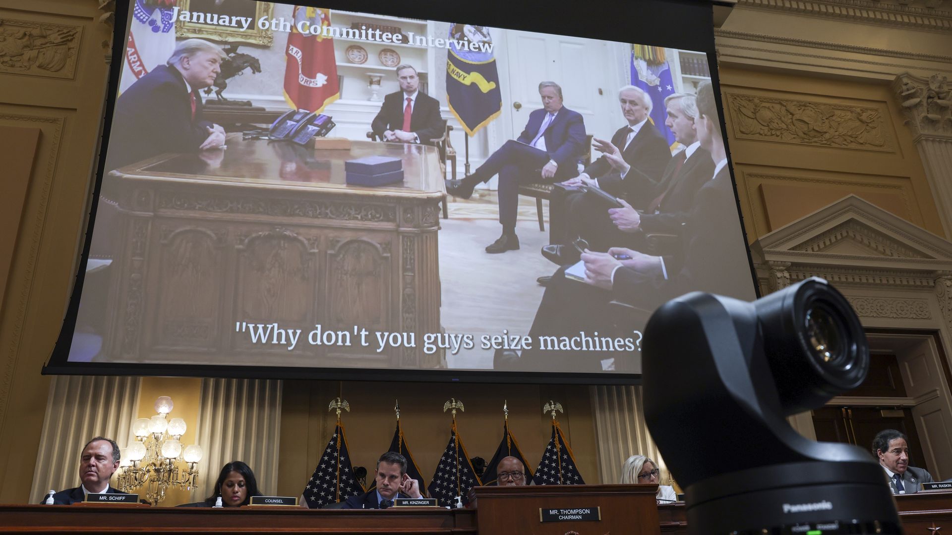 Photo of a video screen showing a picture of Donald Trump and senior DOJ officials with the text "Why don't you guys seize machines?"