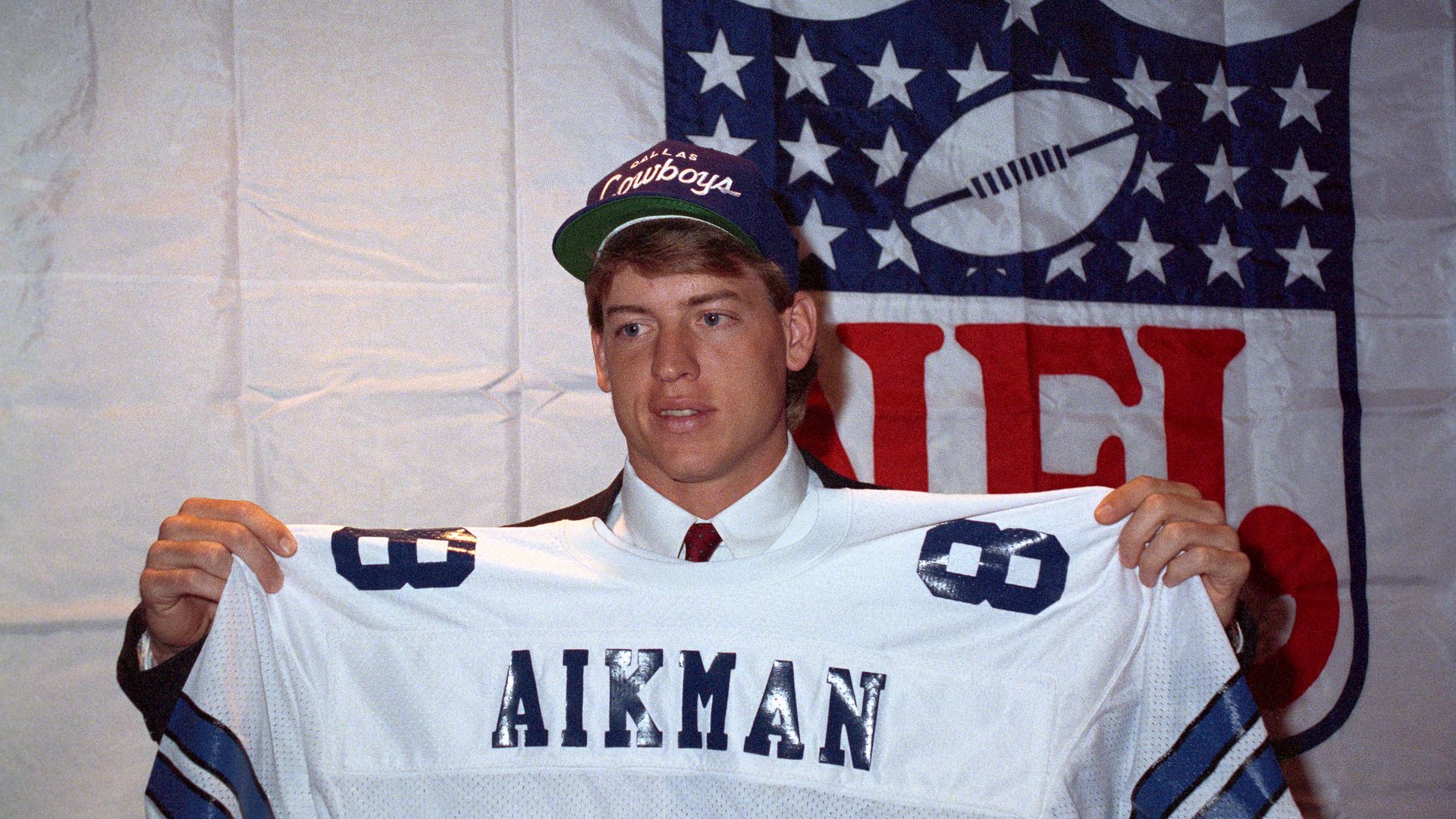 Troy Aikman holding up his jersey