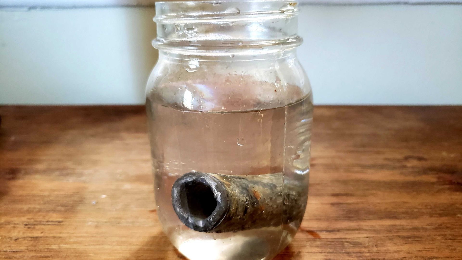 Glass with water and a lead pipe