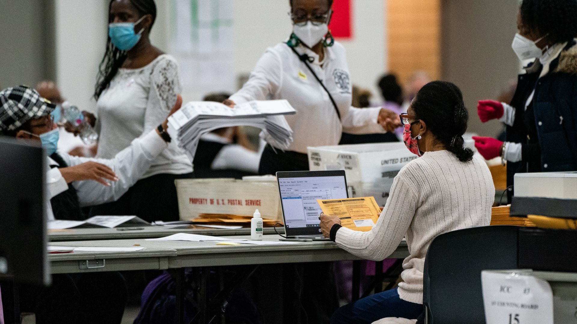 Detroit election workers wear face masks and gloves while counting ballots