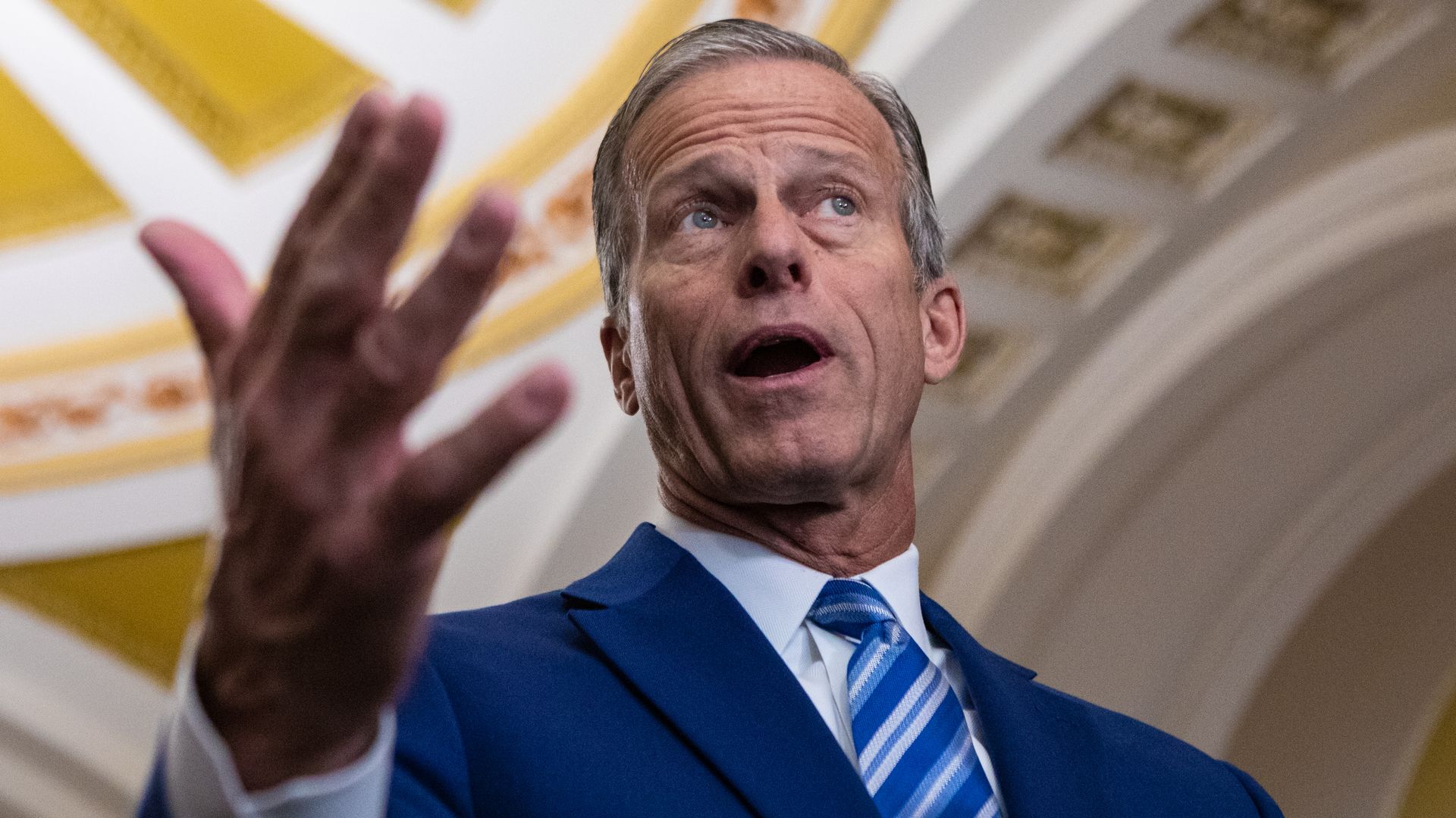 A person in a tie gestures with their hand