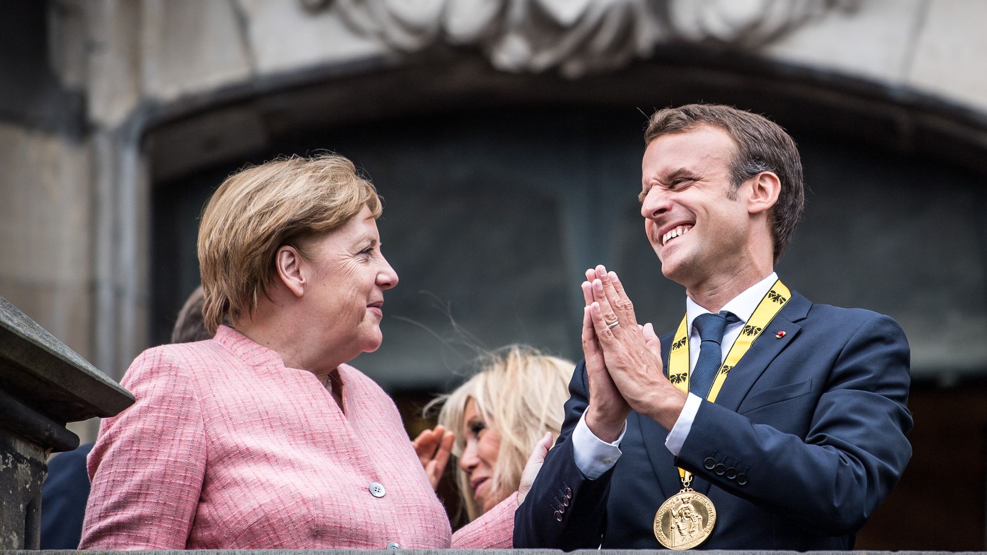 German Chancellor Angela Merkel and French President Emmanuel Macron gesture on the balcony of the town hall of Aachen