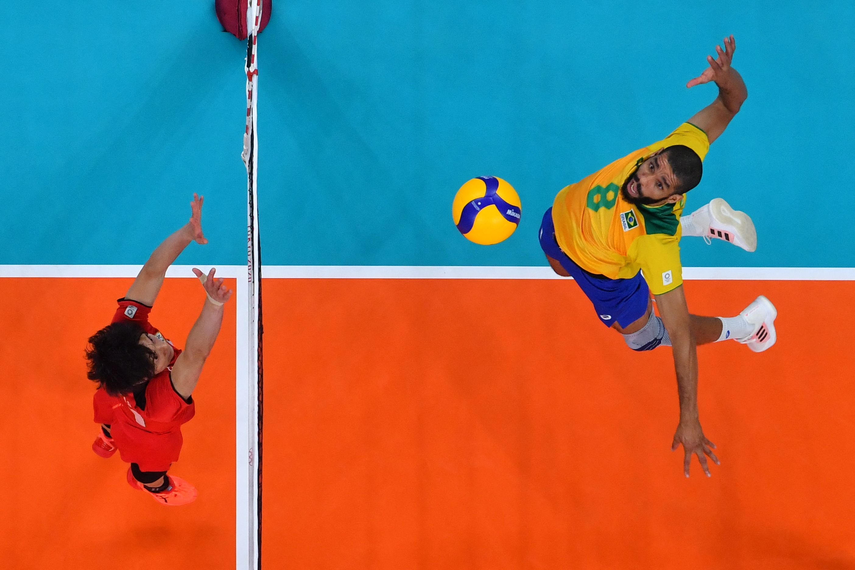 Brazil's Wallace de Souza (R) spikes the ball in the men's quarter-final volleyball match between Japan and Brazil during the Tokyo 2020 Olympic Games at Ariake Arena in Tokyo on August 3