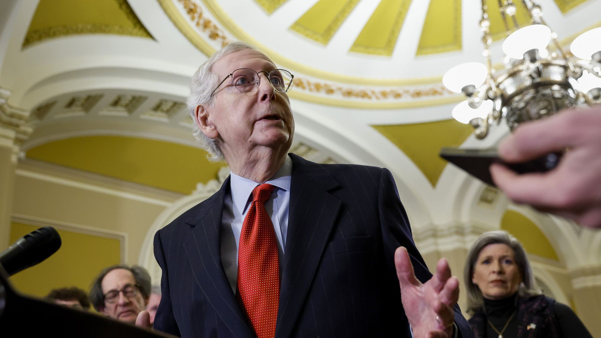 Mitch McConnell, photographed from underneath, speaks at a lectern 