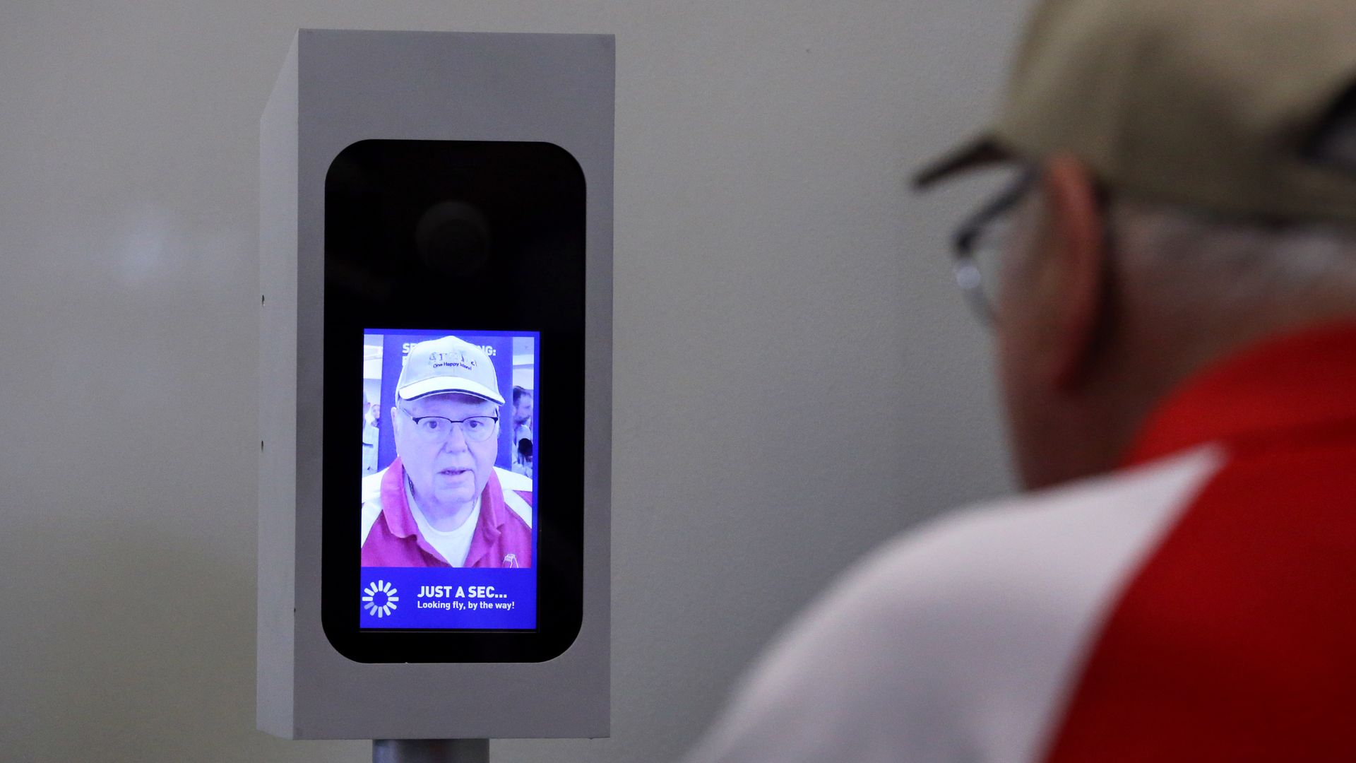 A man uses a facial-recognition system camera to board a JetBlue flight.