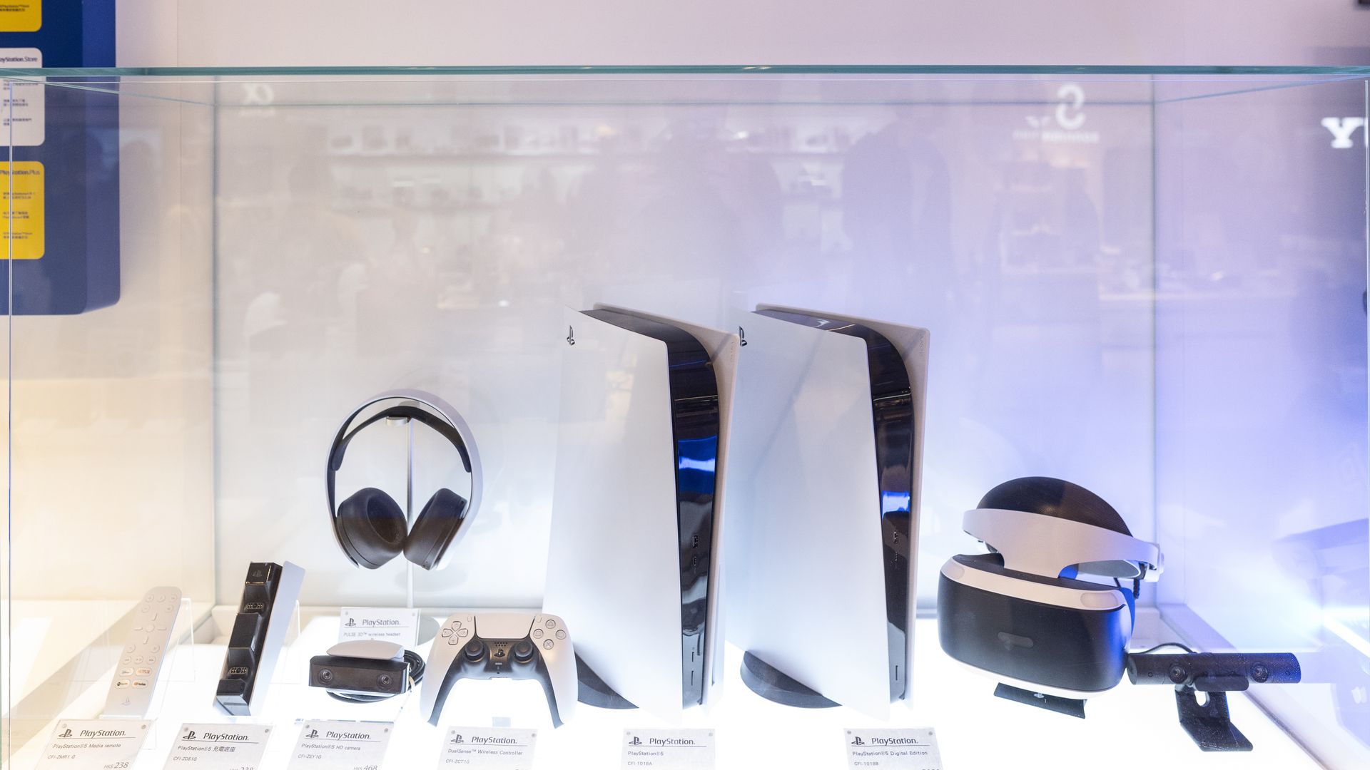 PlayStation 5 hardware, controller and other peripherals in a display case.