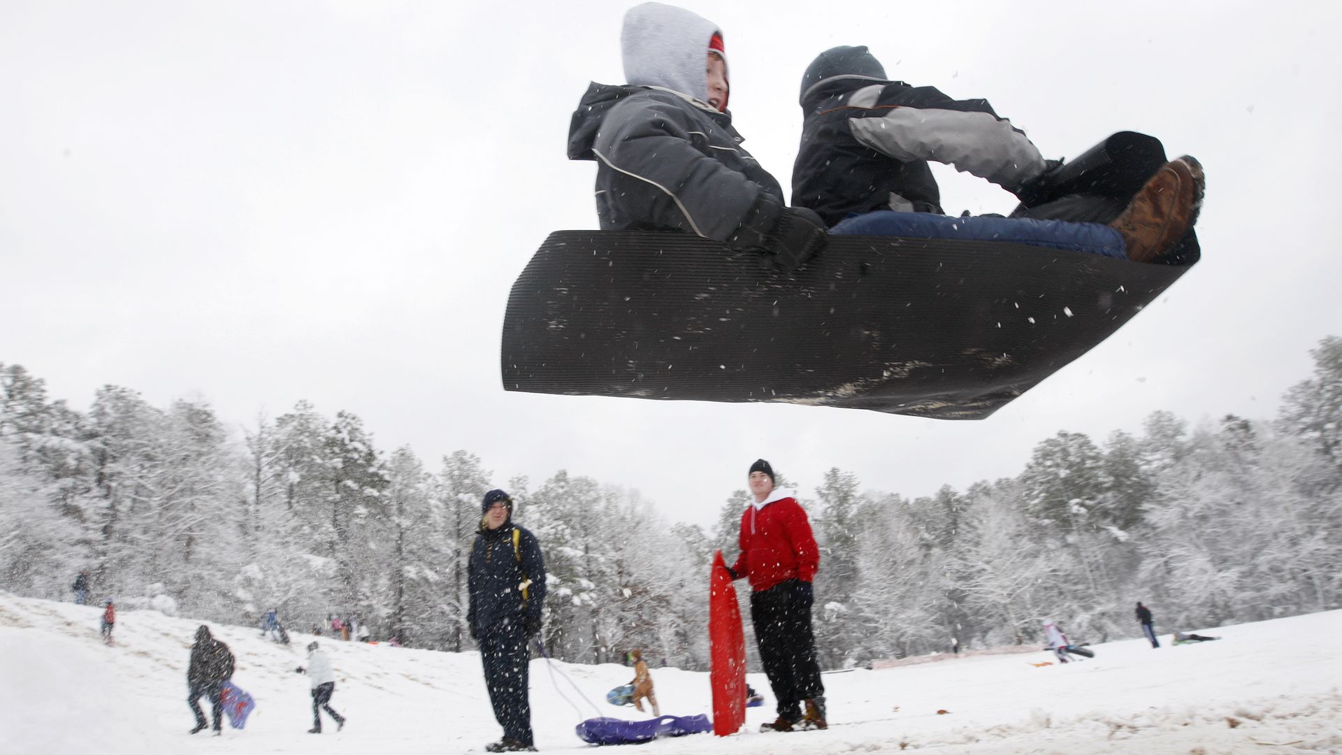 Sledders pilot their mat over a jump made of packed snow in Cary on Christmas Day 2010