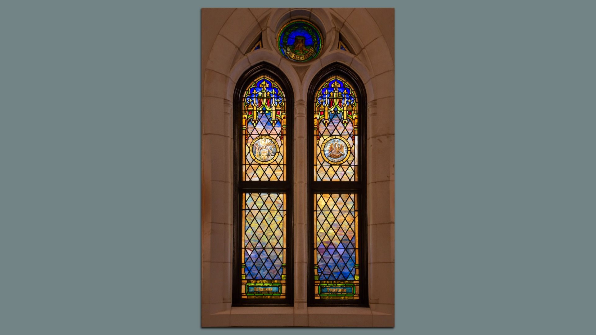 A photo of two narrow stained-glass windows made by Tiffany.
