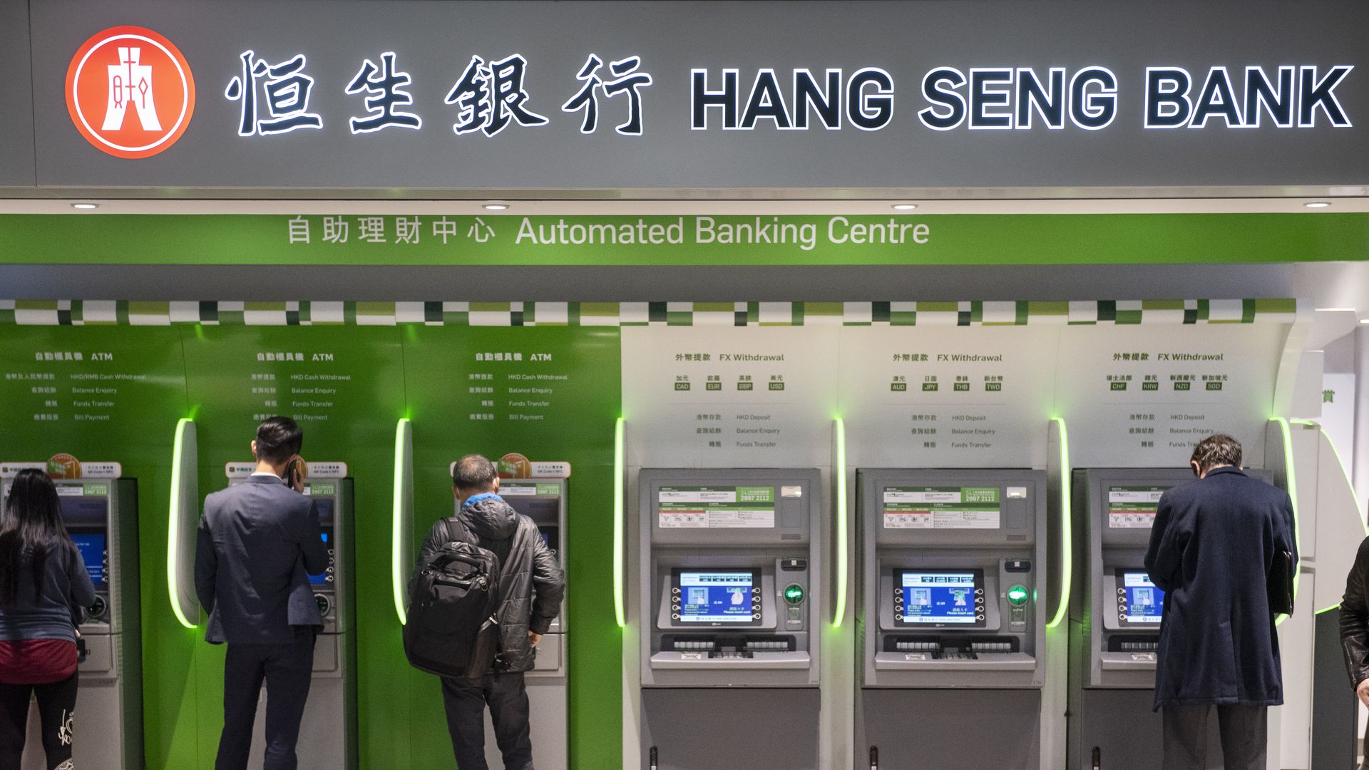 Clients withdraw money from a Hang Seng Bank ATM 