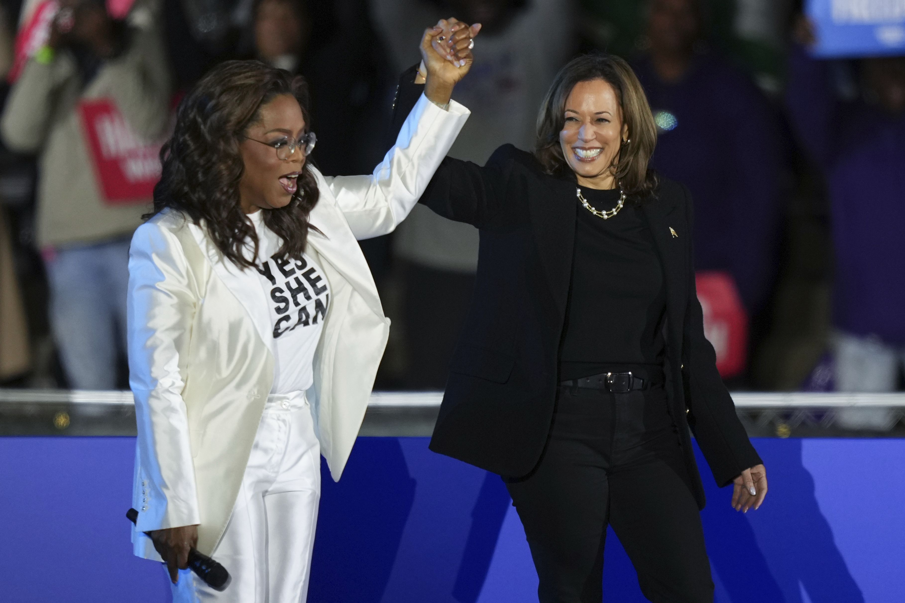 Oprah Winfrey holds hands with Democratic presidential nominee Vice President Kamala Harris after introducing Harris to speak during a campaign rally outside the Philadelphia Museum of Art,