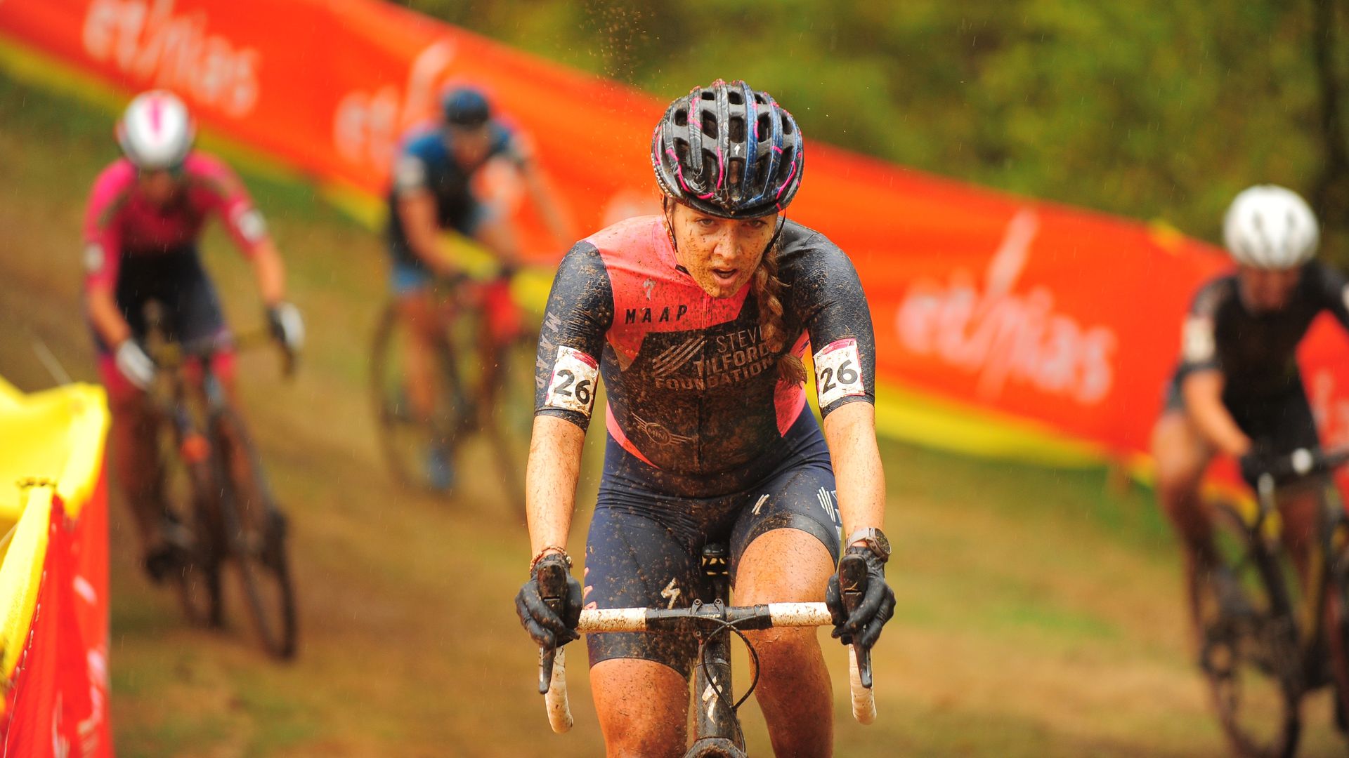 Determined woman racing a bike in the rain.
