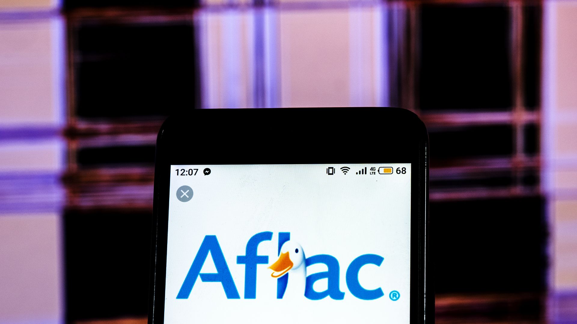 Image of a photo illustration of the Aflac Insurance company logo displayed on a smartphone.