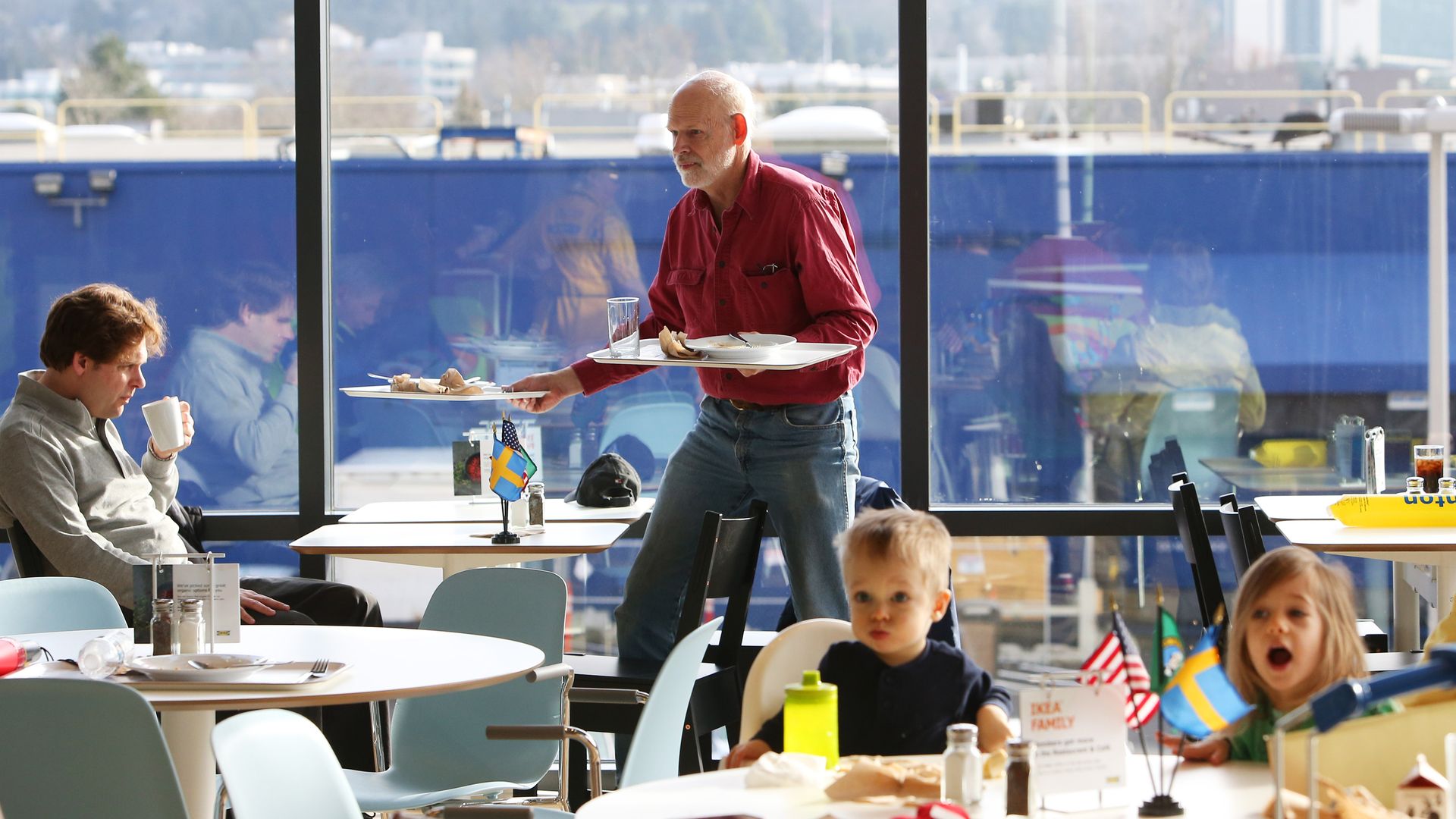 Photo of a man holding plates while walking in IKEA's food hall