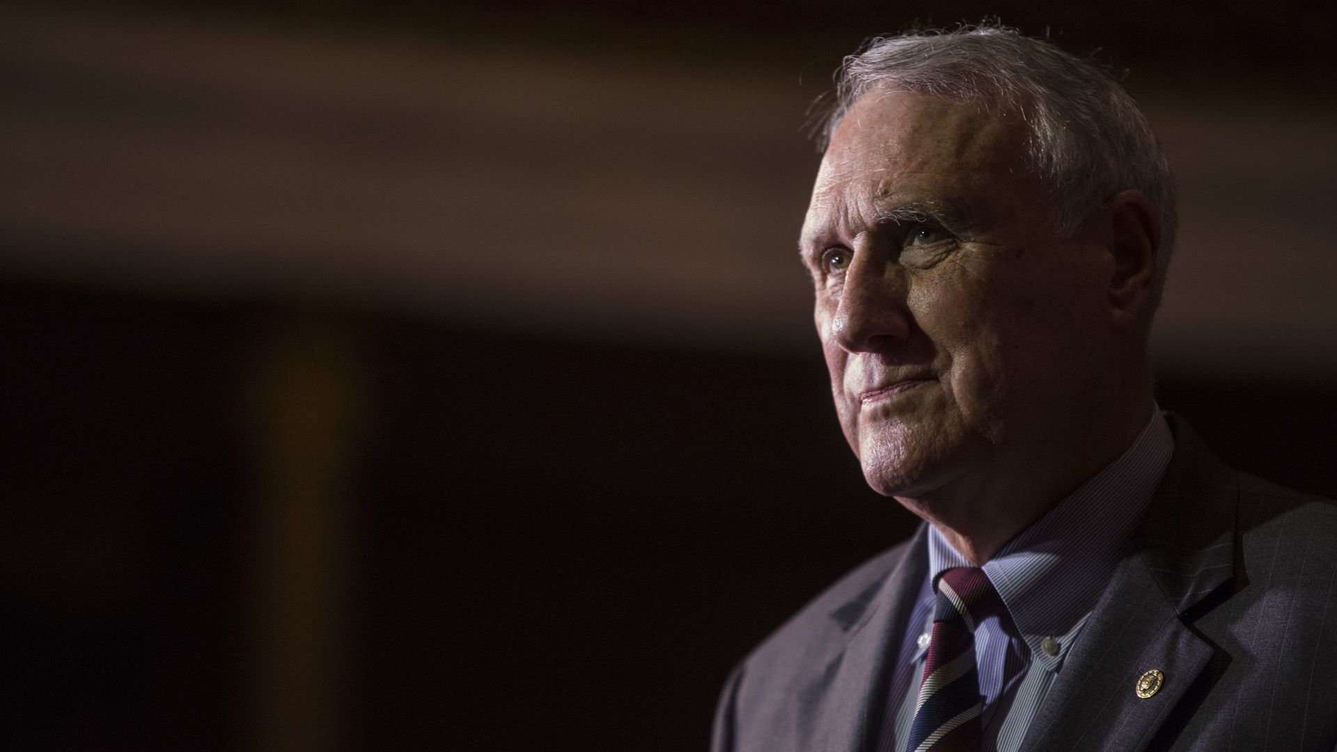 Jon Kyl stands looking to the side