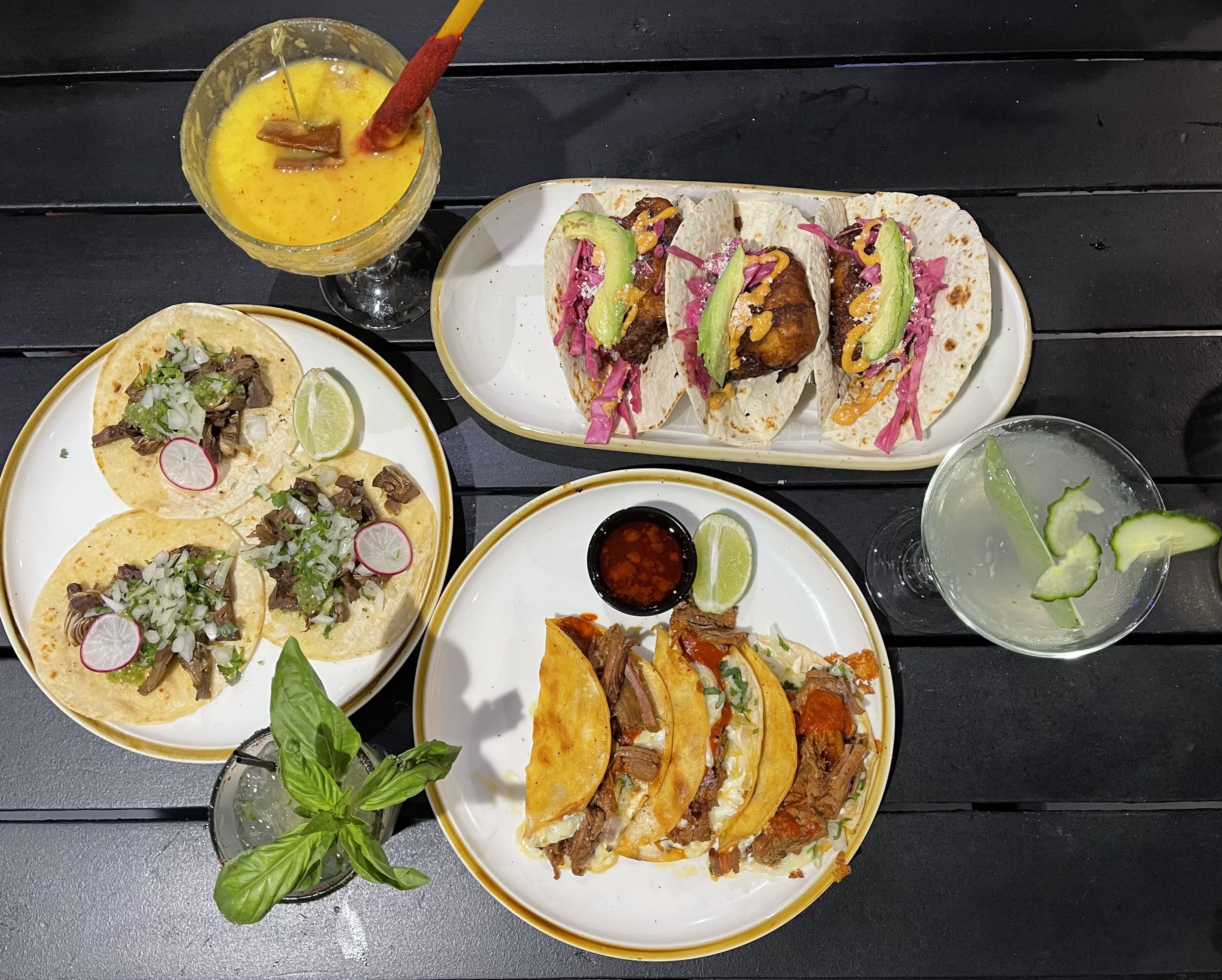 a table of tacos and drinks