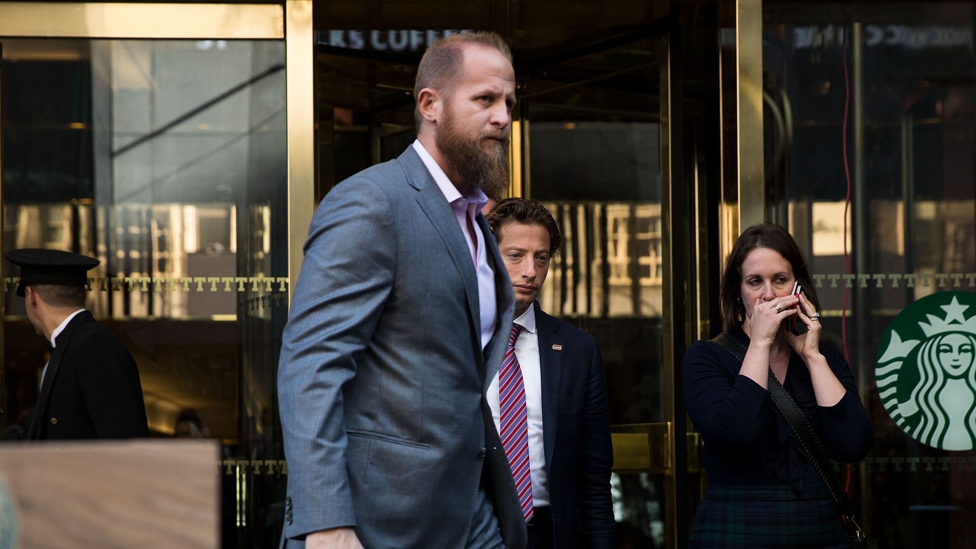 Brad Parscale walking in front of a Starbucks in a grey suit