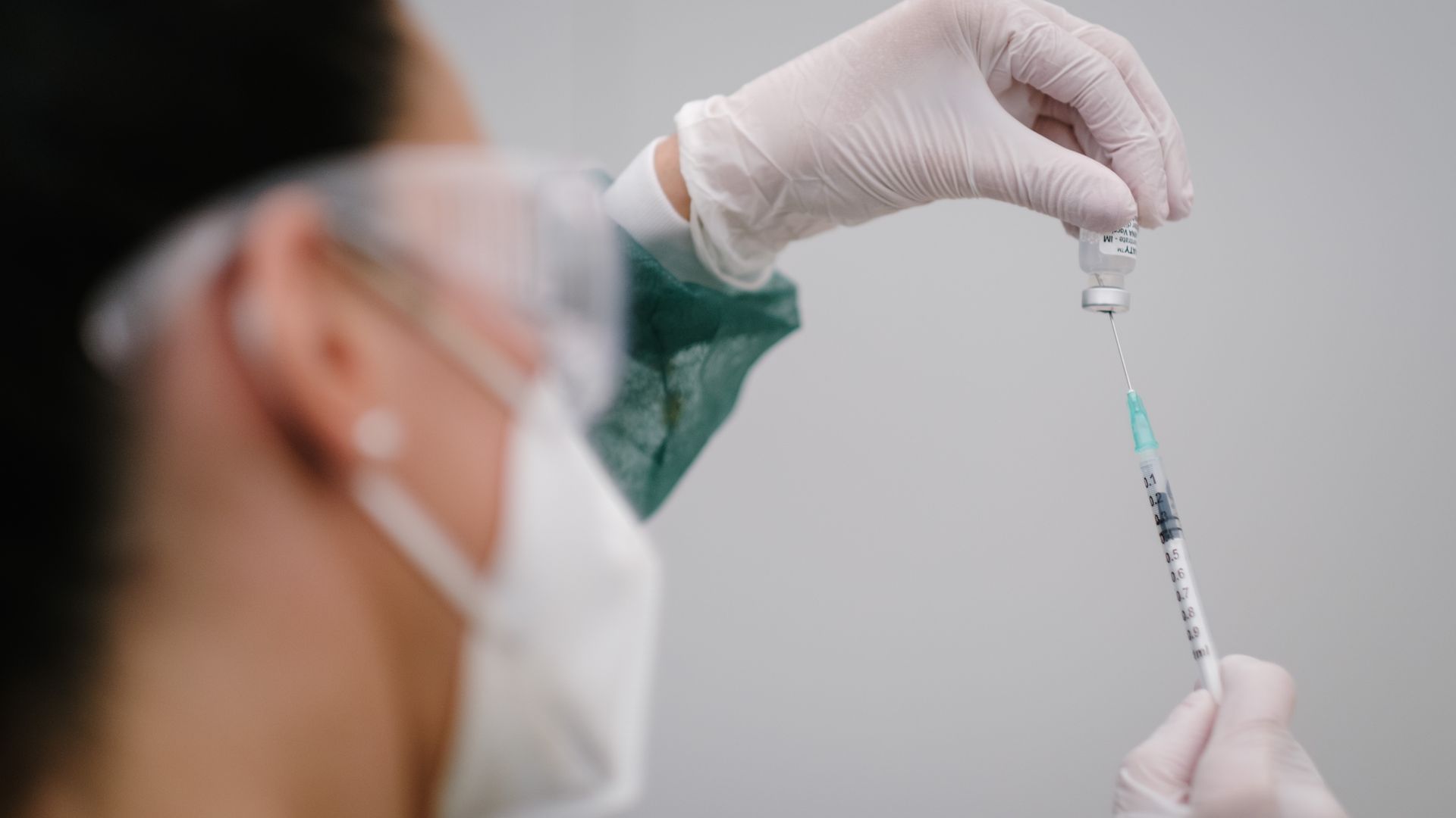 Photo of a person holding a COVID vaccine syringe