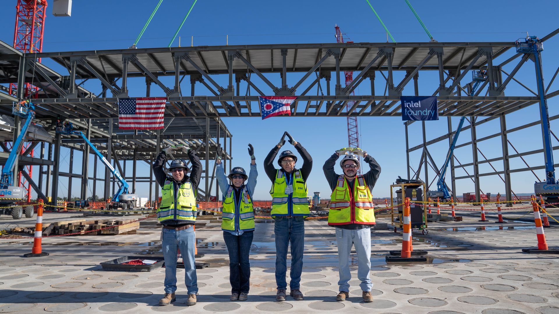 Four construction workers do the Ohio State O-H-I-O pose in front of Intel's in-progress Ohio One factory