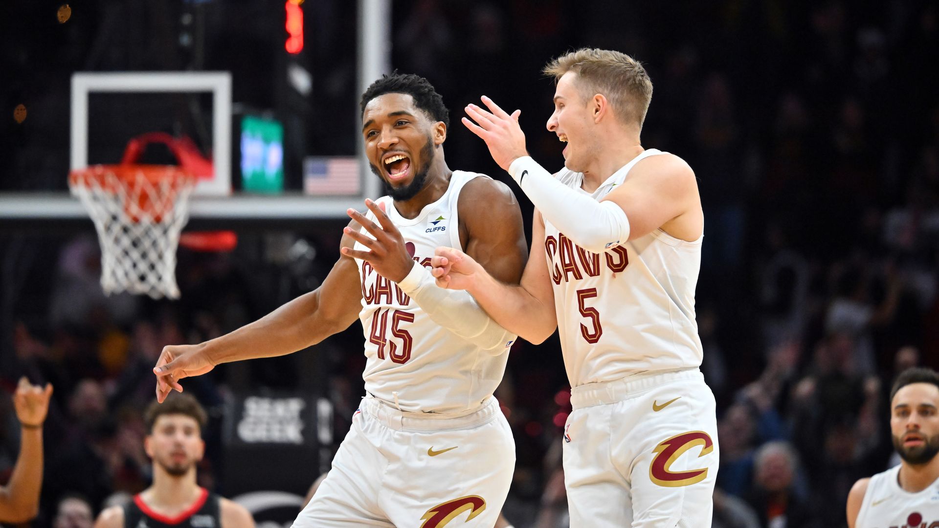 The Cavs' Donovan Mitchell and Sam Merrill celebrate in white jerseys