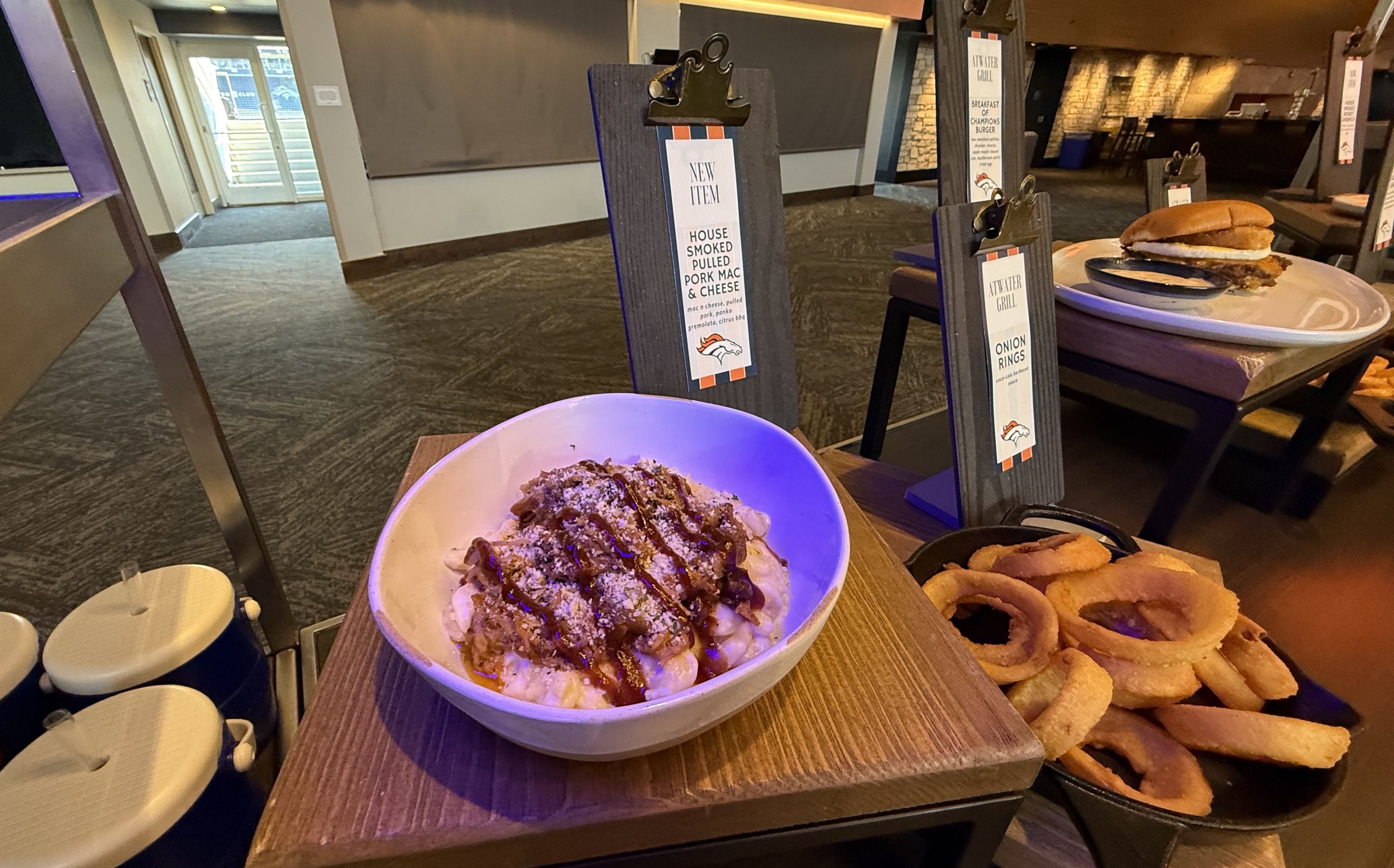 A small bowl of macaroni and cheese with pulled pork and barbecue sauce. 
