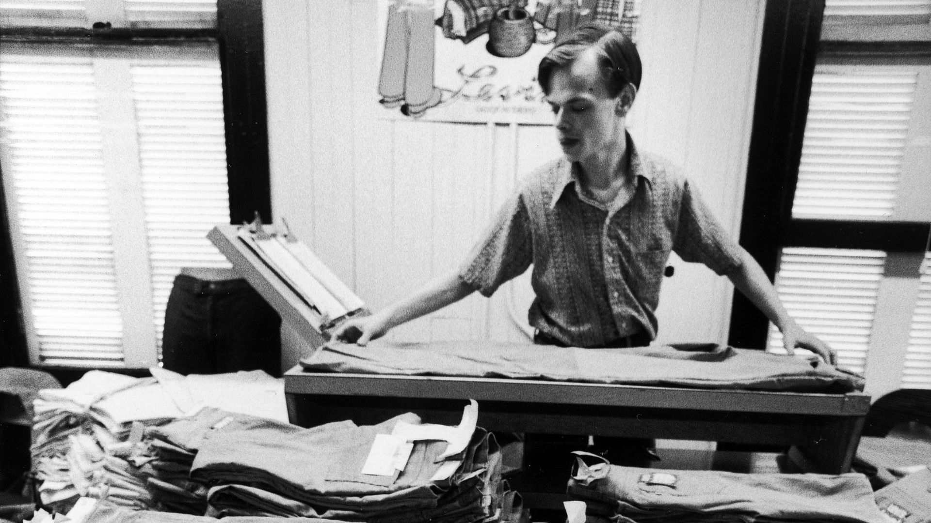 Worker folding pair of Levi's at factory.