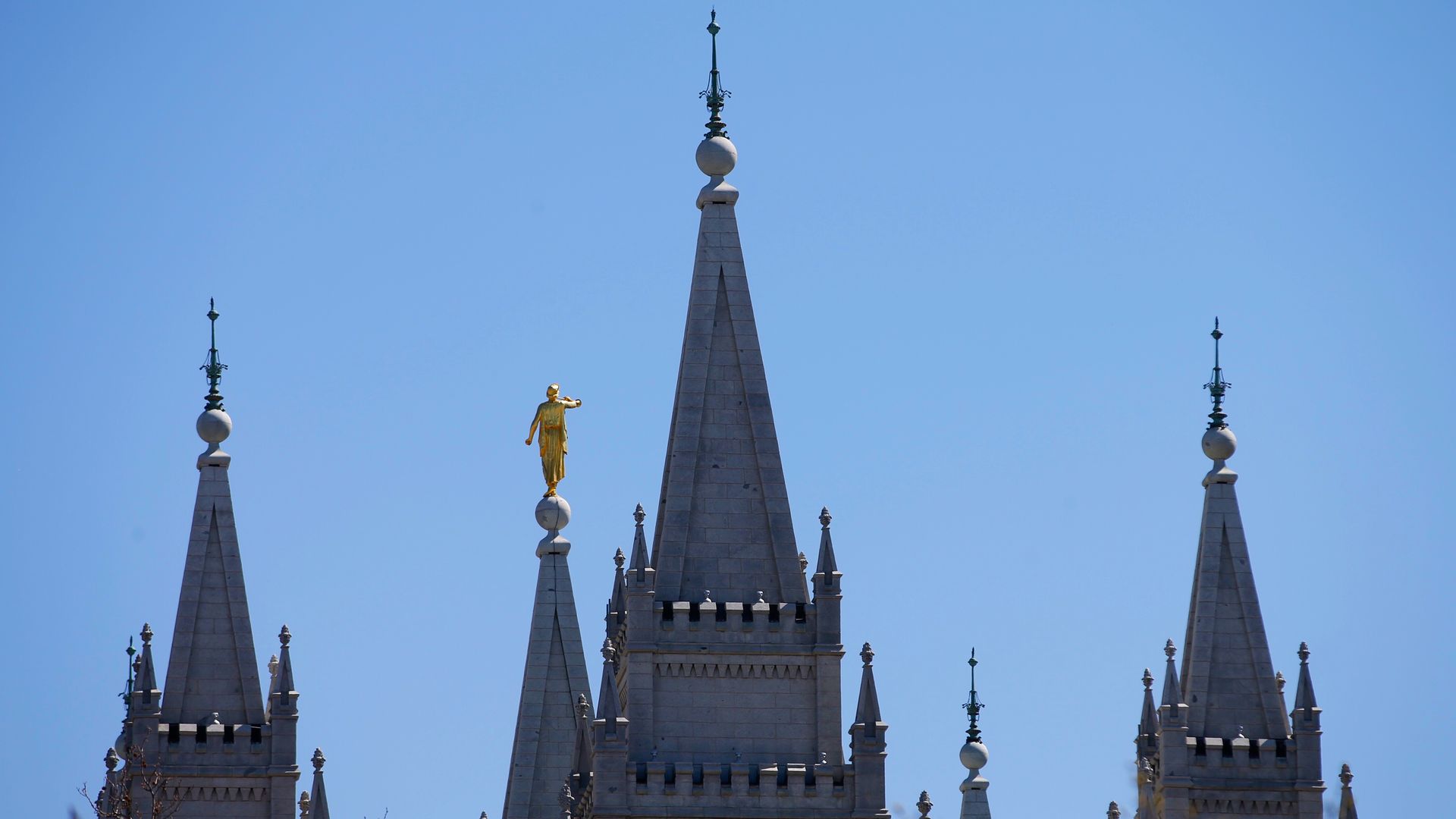The steeples at the Salt Lake City temple appear before a blue sky.
