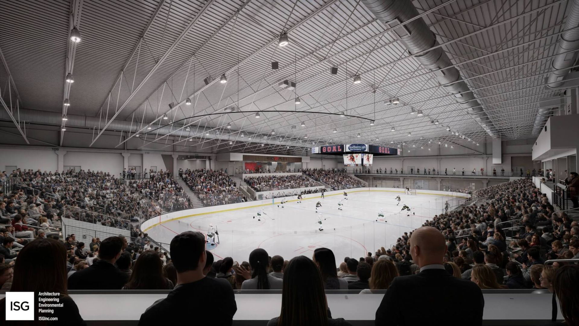 Wide view of a crowded indoor ice hockey arena. Rink at center with players; scoreboard reads GOAL as hanging lights and exposed ducts line the ceiling. ISG logo appears bottom left.