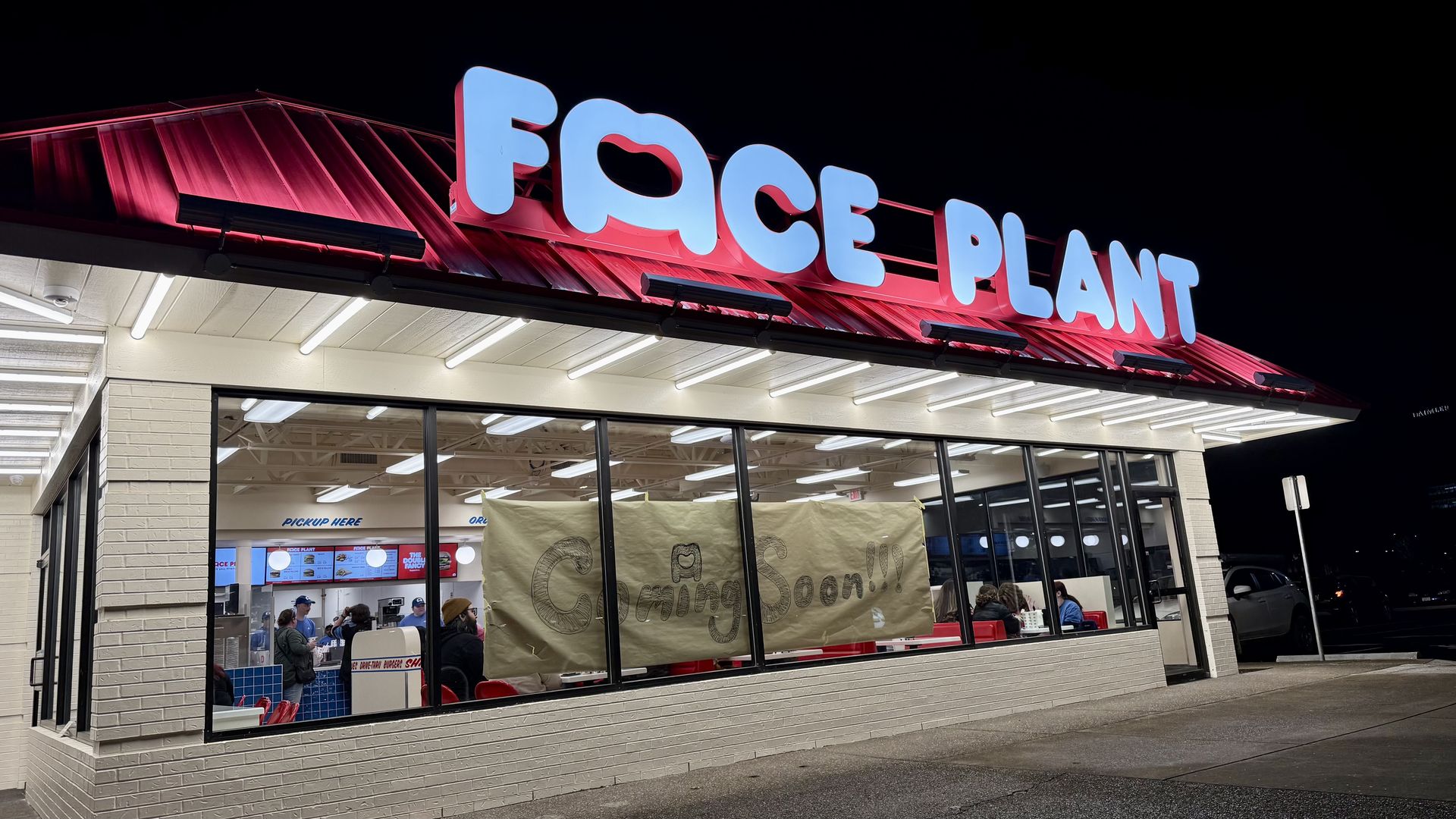 A photo of the outside of a fast food restaurant with a sign that reads "Face Plant" 