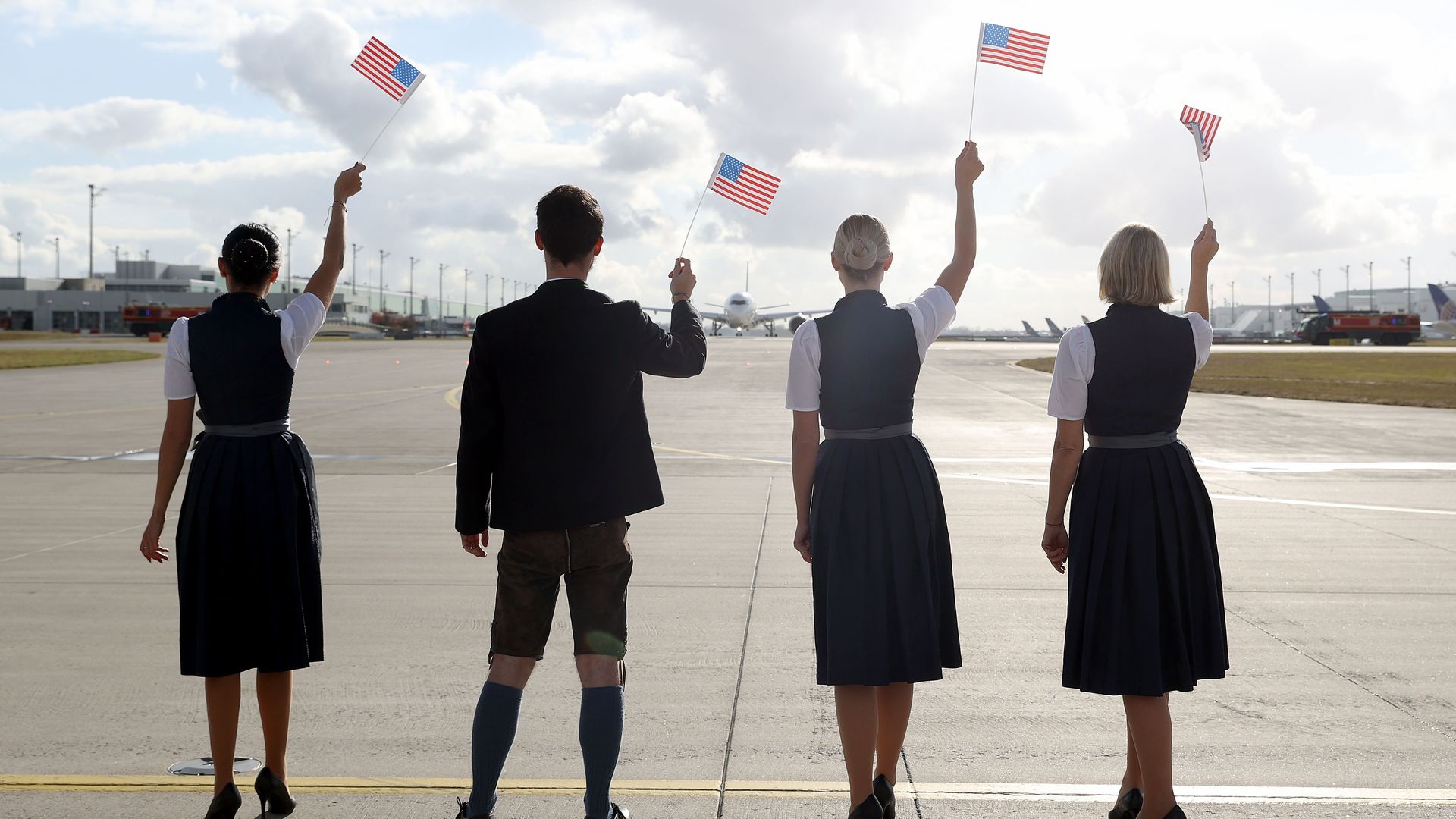 A Luftansa crew waving American flags on the runway