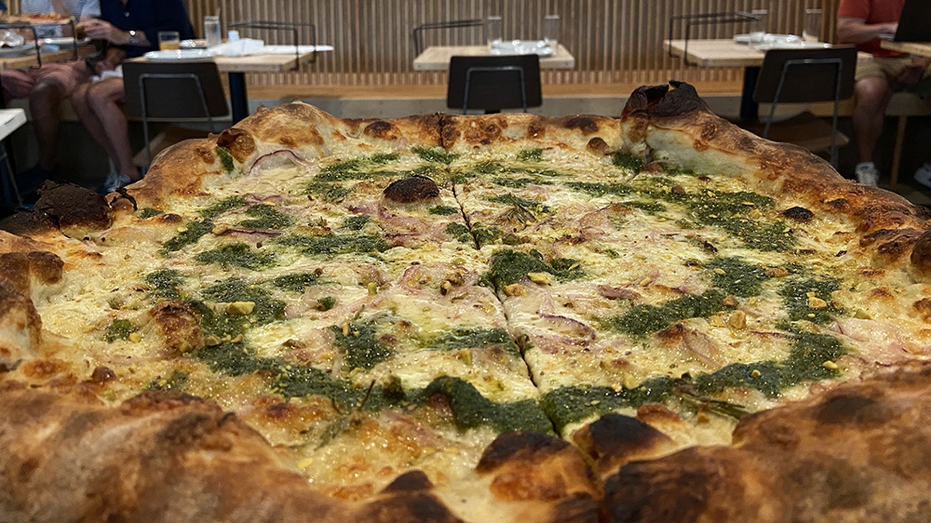 Pizza Baby West rosemary pizza with pistachio pesto, shaved red onion, hot honey and pecorino. ($27) Photo: Ashley Mahoney/Axios