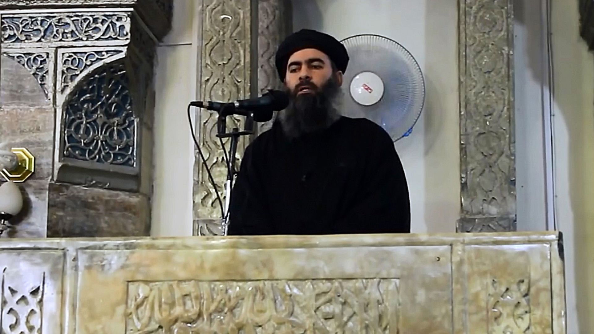 Abu Bakr al-Baghdadi in video footage speaking at a microphone. 