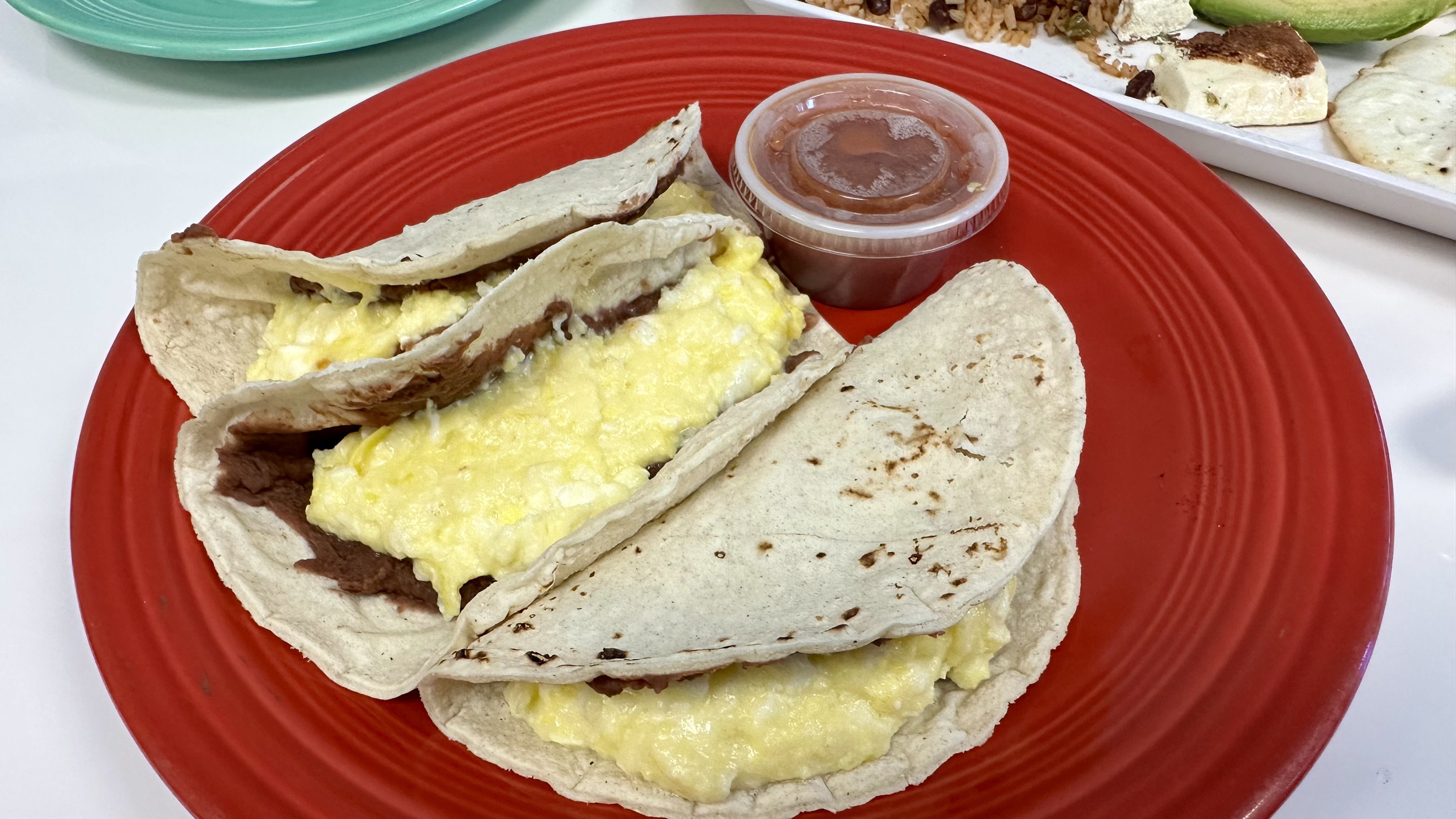 Photo shows egg, bean and cheese tacos.