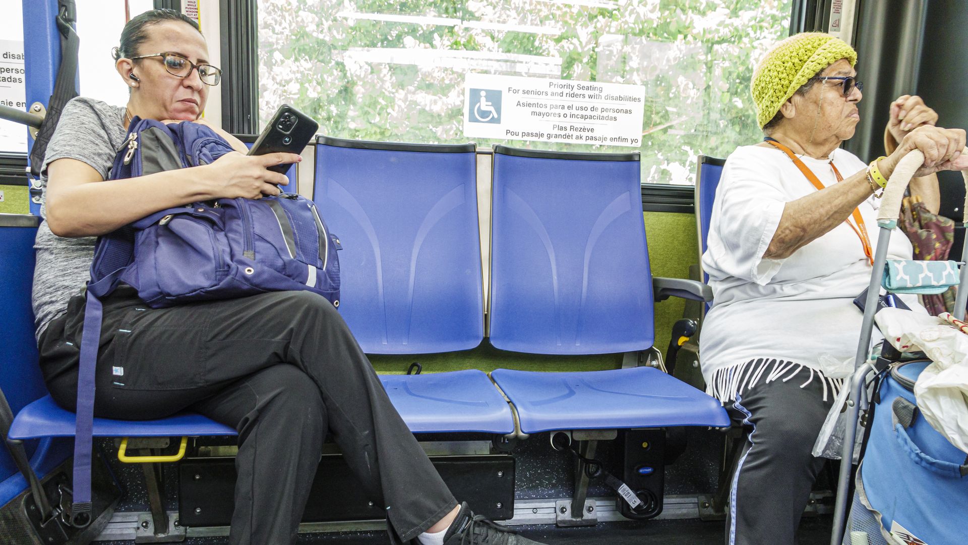 A woman looks on her smartphone while riding on Miami-Dade Metrobus public transportation.