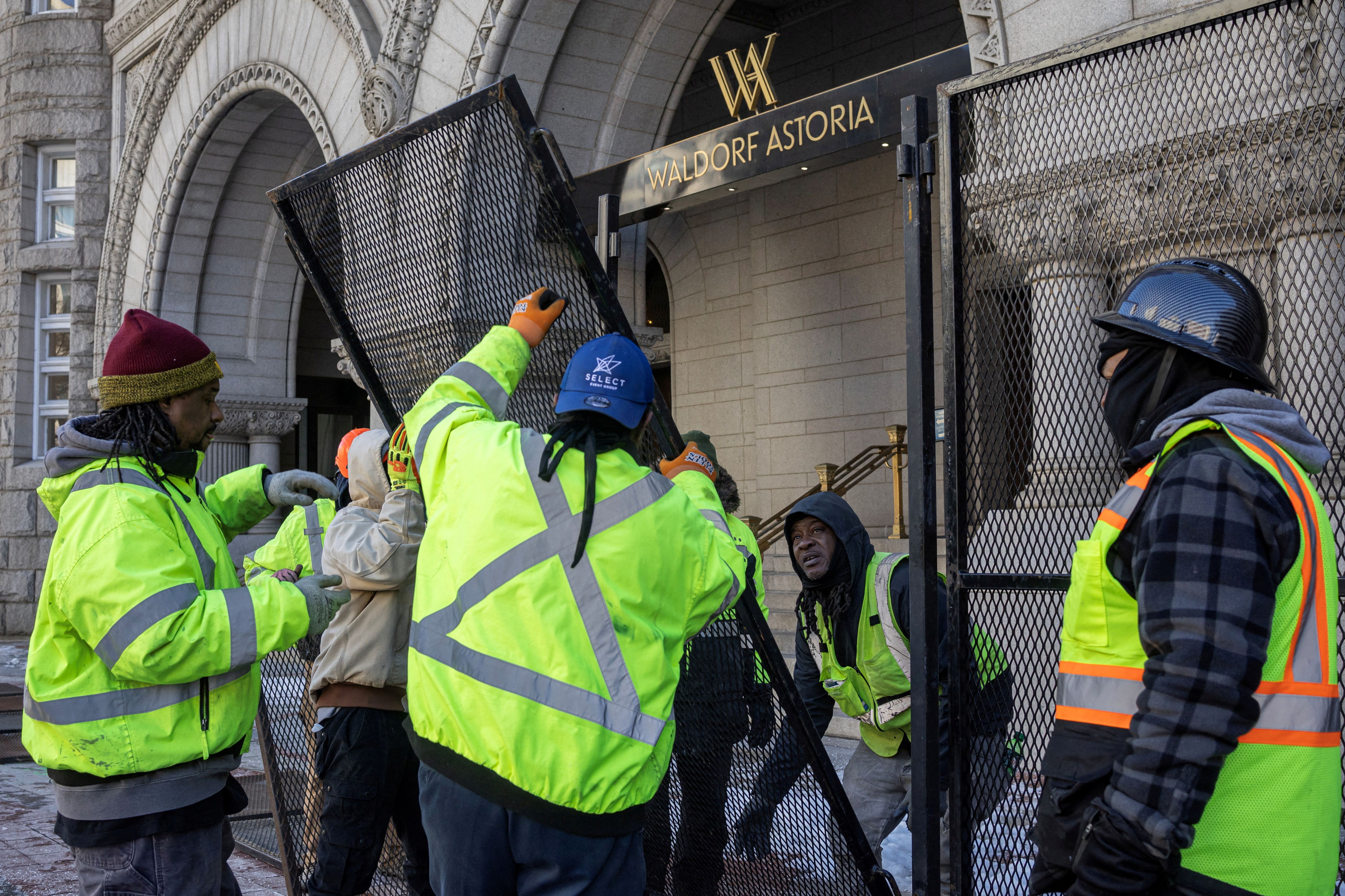 Workers install security fencing yesterday outside the Waldorf Astoria, formerly the Trump International Hotel, on Pennsylvania Avenue. Photo: Marko Djurica/Reuters