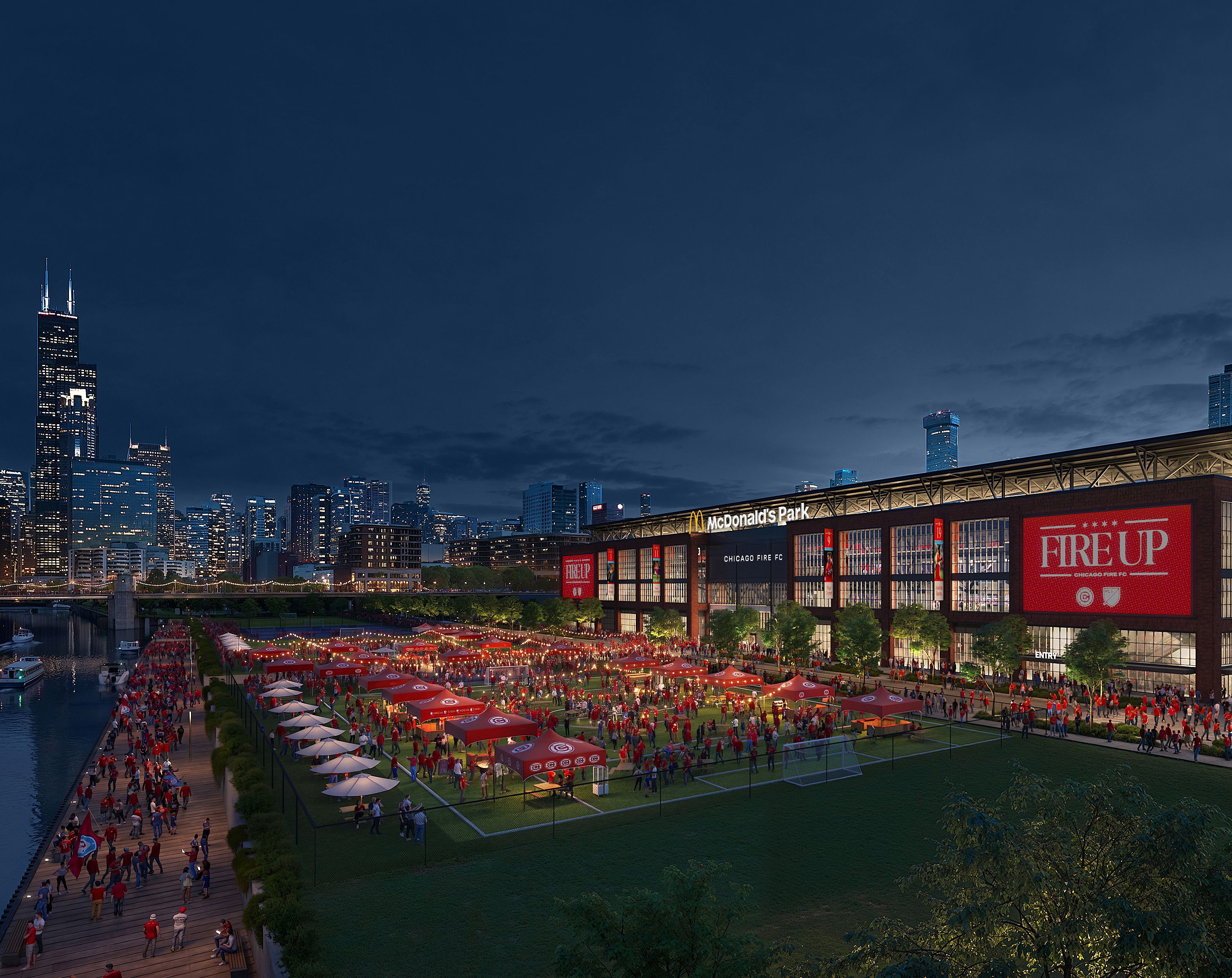 Dusk cityscape with a riverfront stadium packed with people under red umbrellas; banners read "FIRE UP" for Chicago Fire FC. On the left rises the Willis Tower against a deep blue sky.