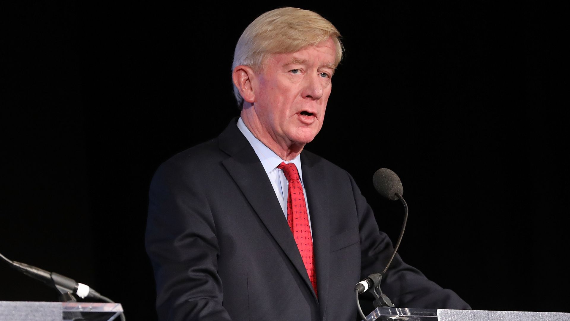 weld standing at a podium.