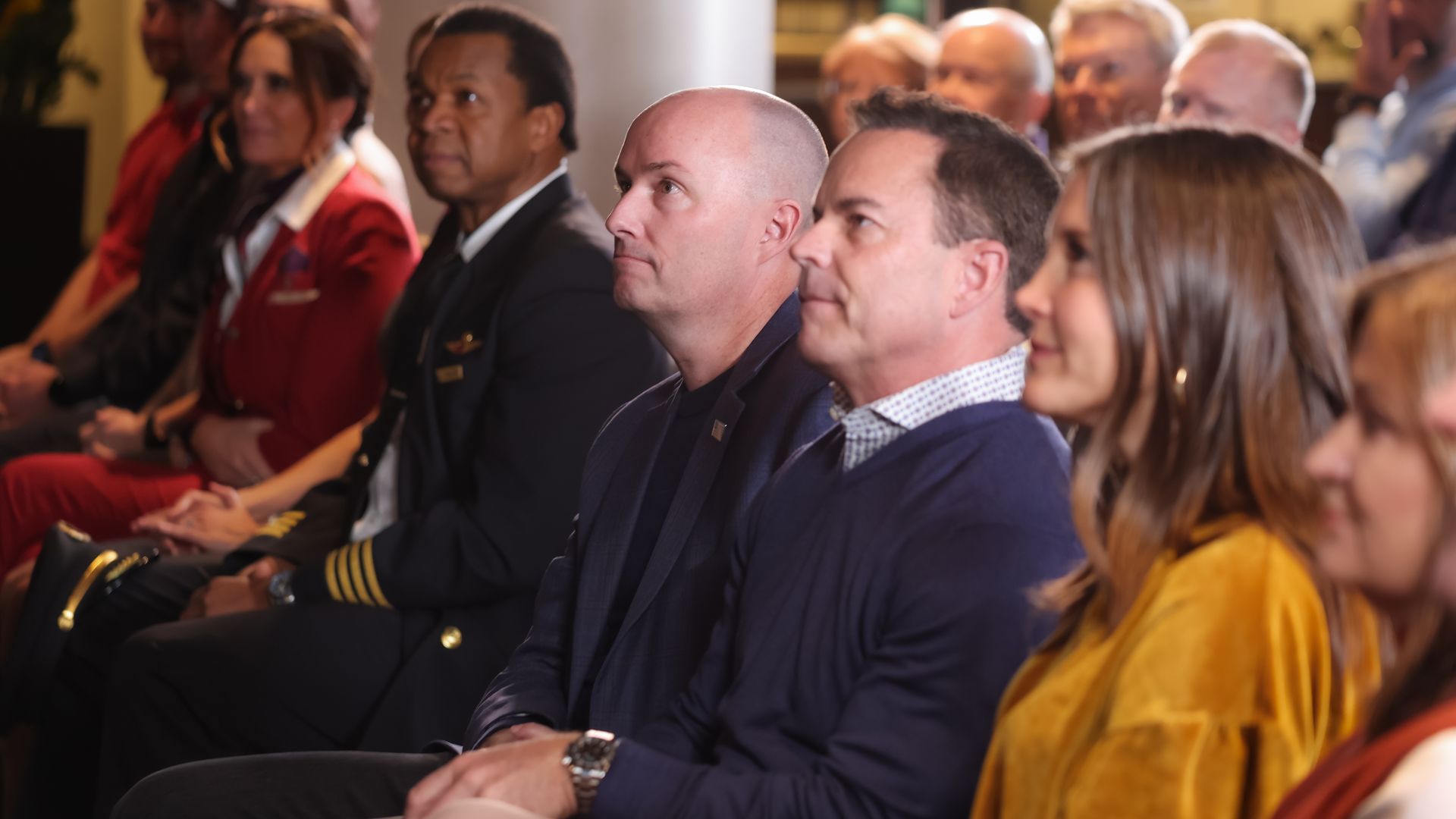 Gov. Spencer Cox (left), former House Speaker Brad Wilson and Salt Lake City Mayor Erin Mendenhall sit down and listen to a speaker.