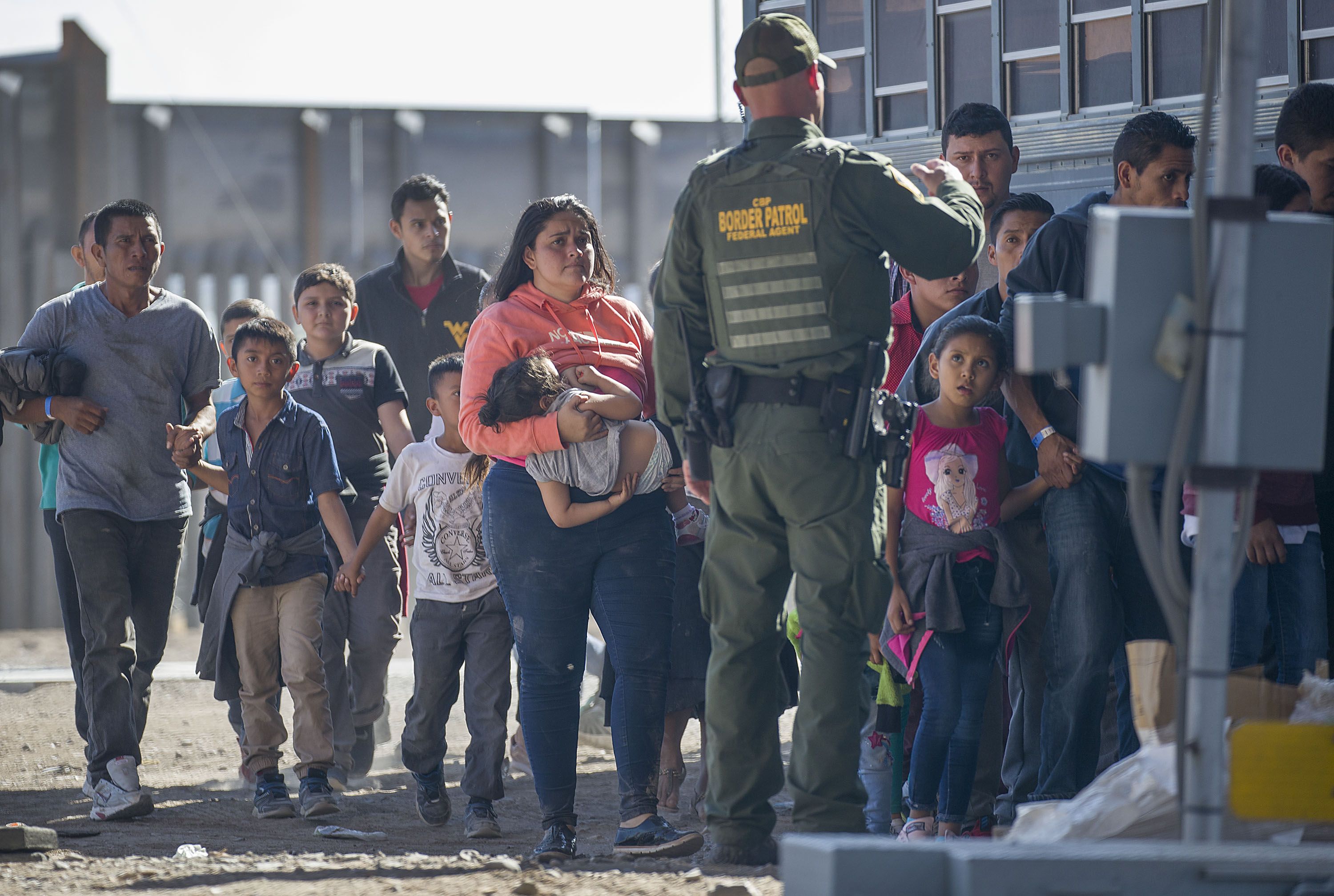 Migrants are loaded onto a bus by U.S. Border Patrol agents after being detained when they crossed into the United States from Mexico on June 01,
